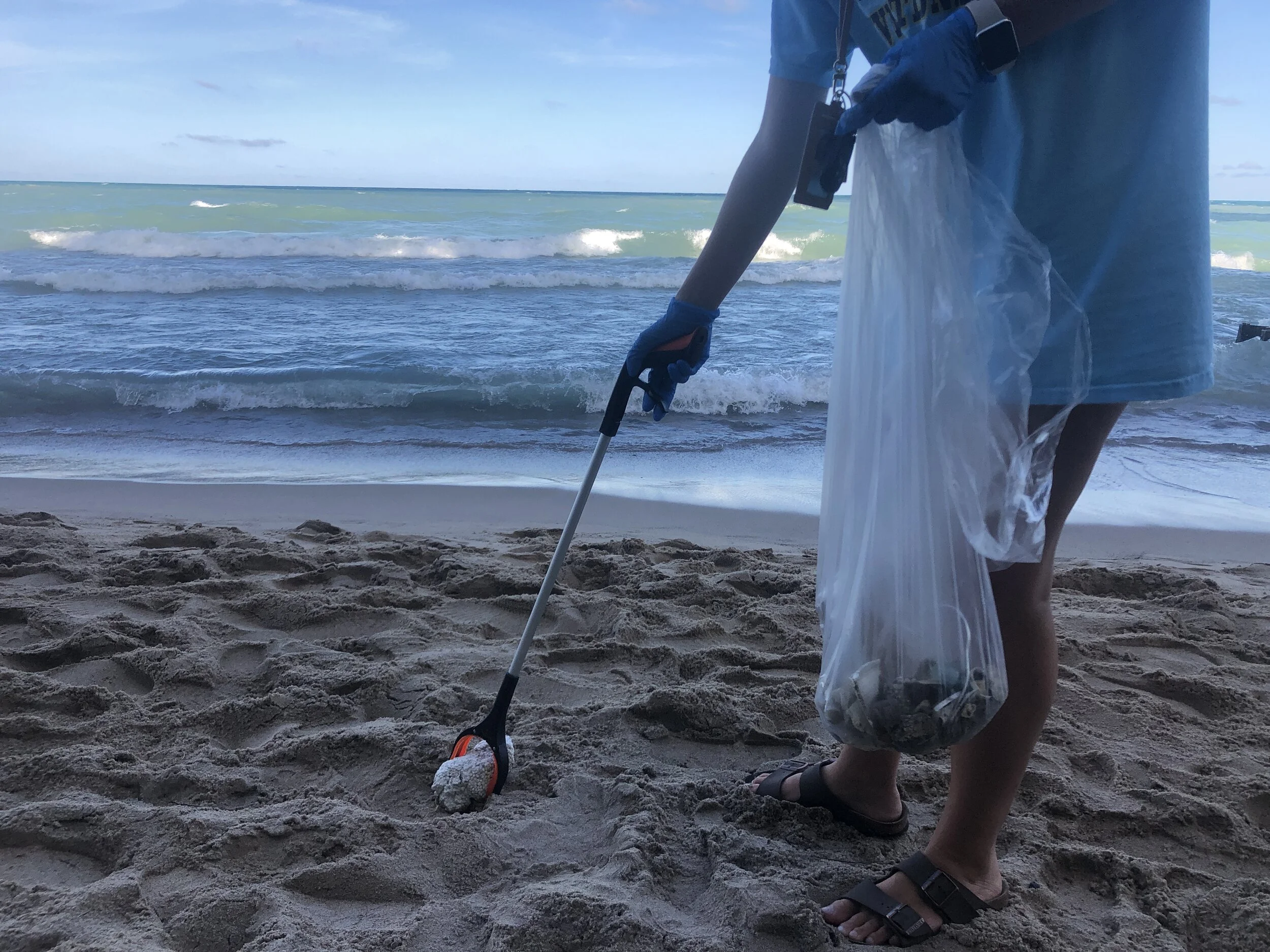 Student, Claire Caplea, picks up styrofoam she found on the beach.