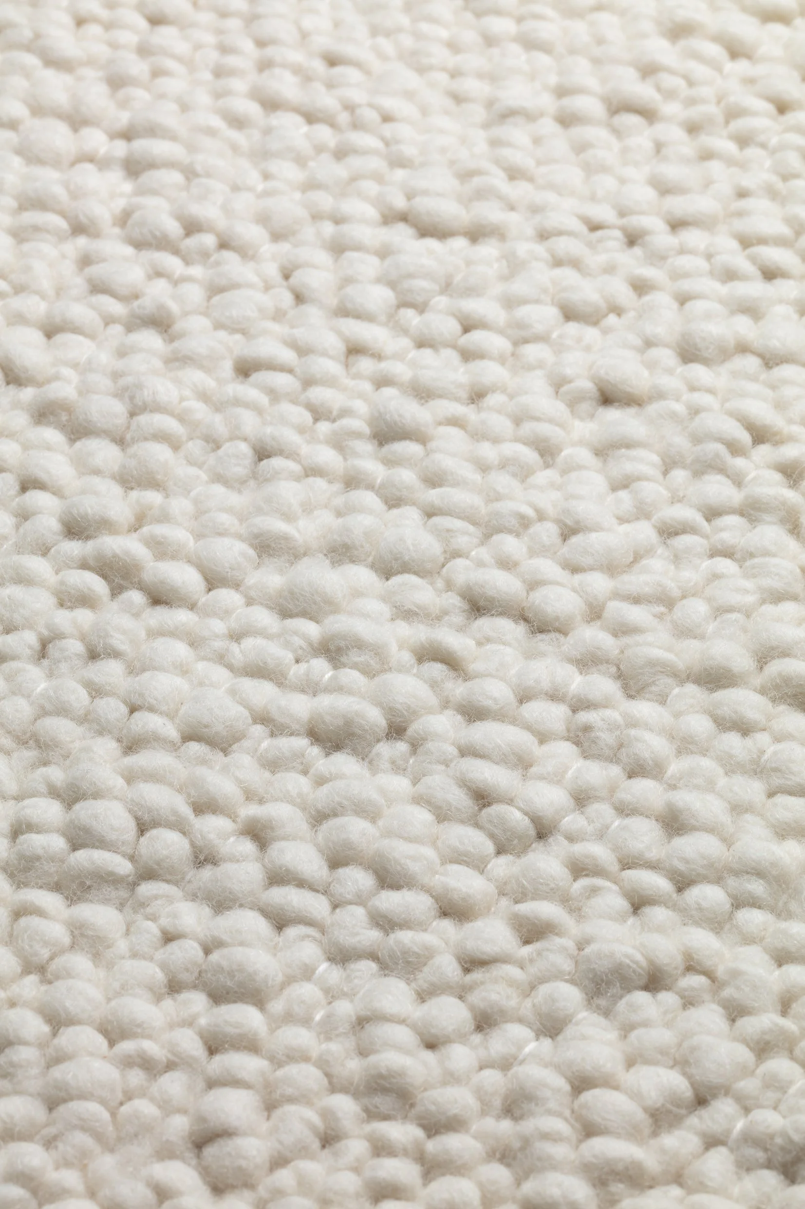 Close-up of a textured white knitted fabric or material.