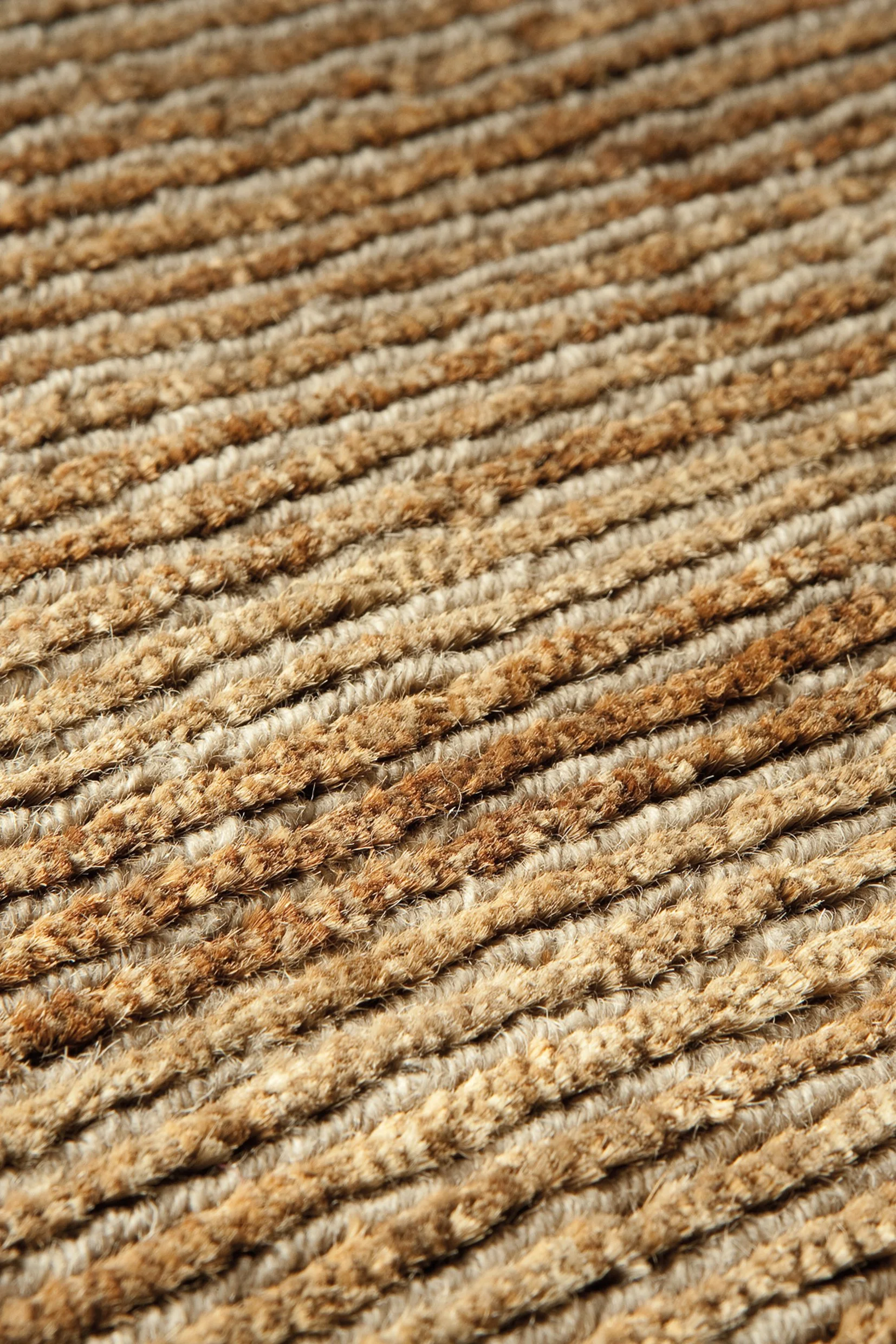 Close-up of brown and beige striped carpet with textured fibers.
