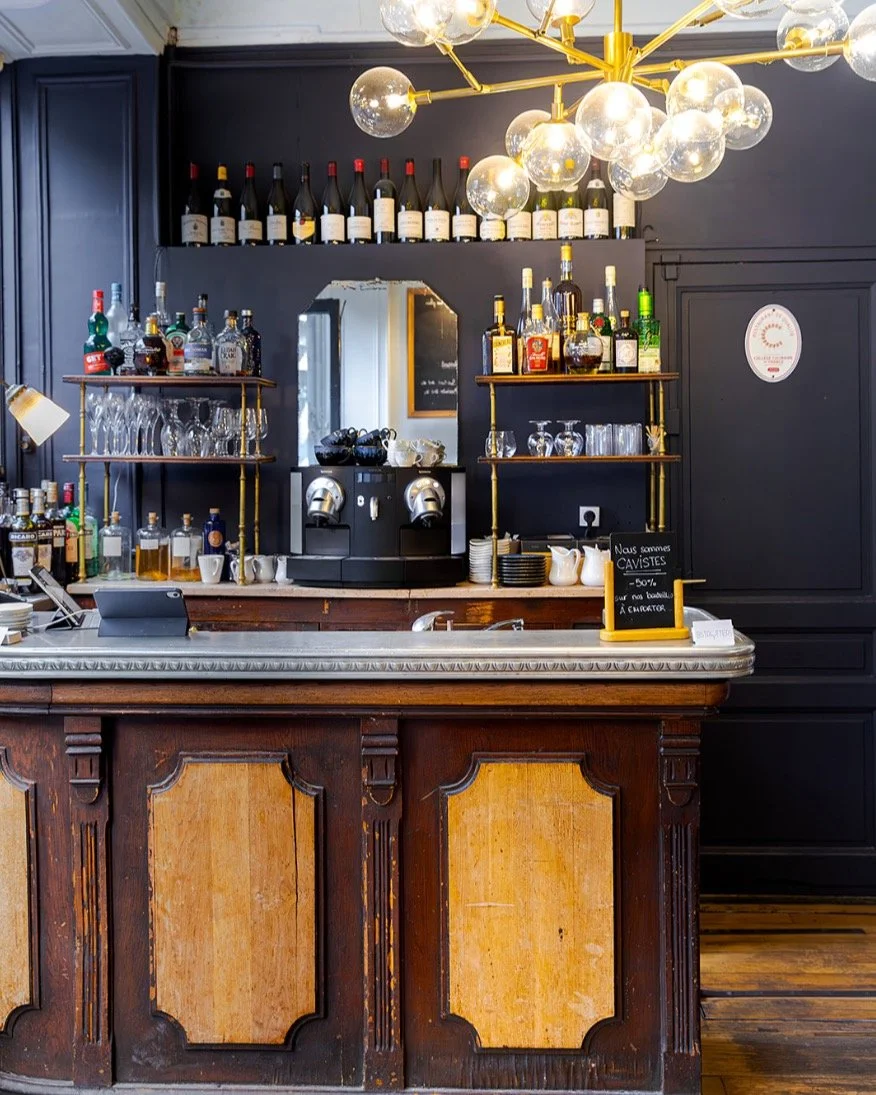 Our bar greets you on arrival, centered around a tin counter crafted by the famous Ateliers Nectoux Paris. The bar is not a consumption area (no food or drinks served there). It is dedicated to welcoming guests — yet it is essential to the char