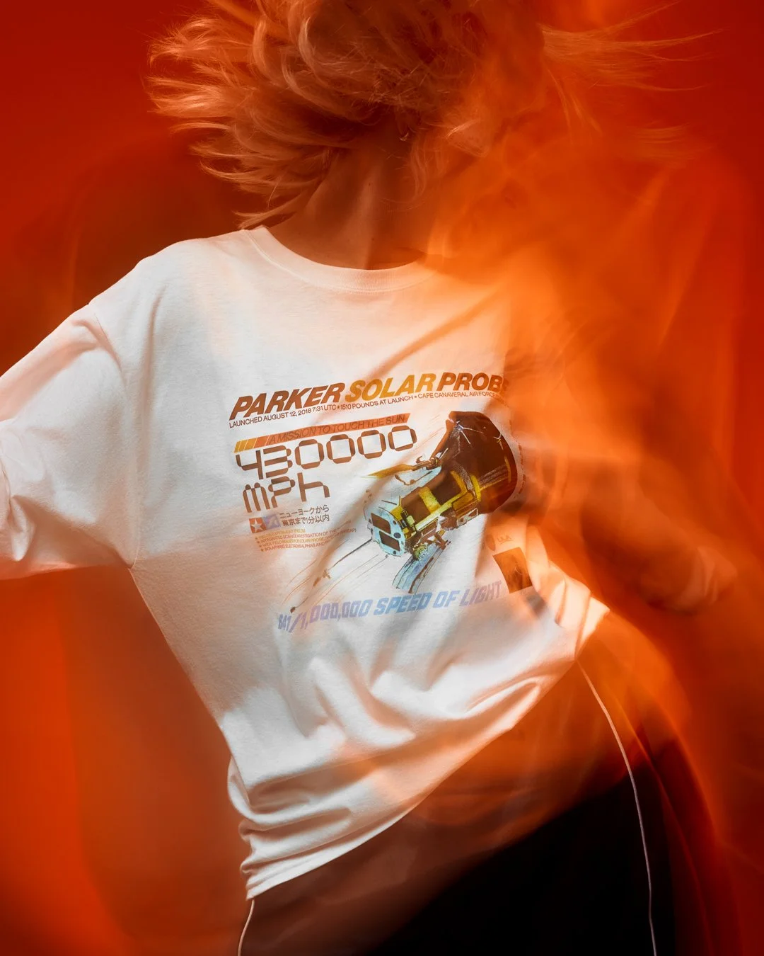 Model wearing Supercluster Parker Solar Probe Racing Team long sleeve shirt with orange motion blur lighting for Supercluster apparel campaign.