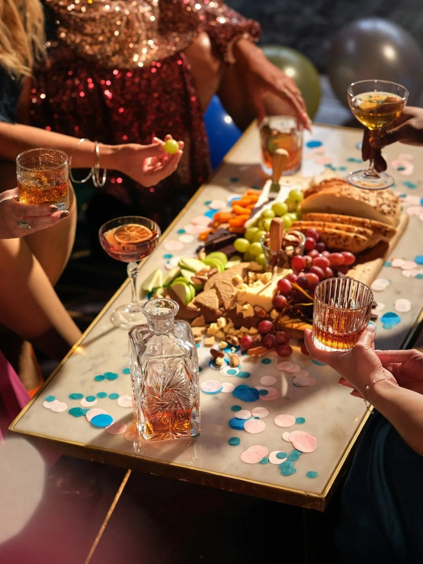 A group celebrating around a table with food and drinks