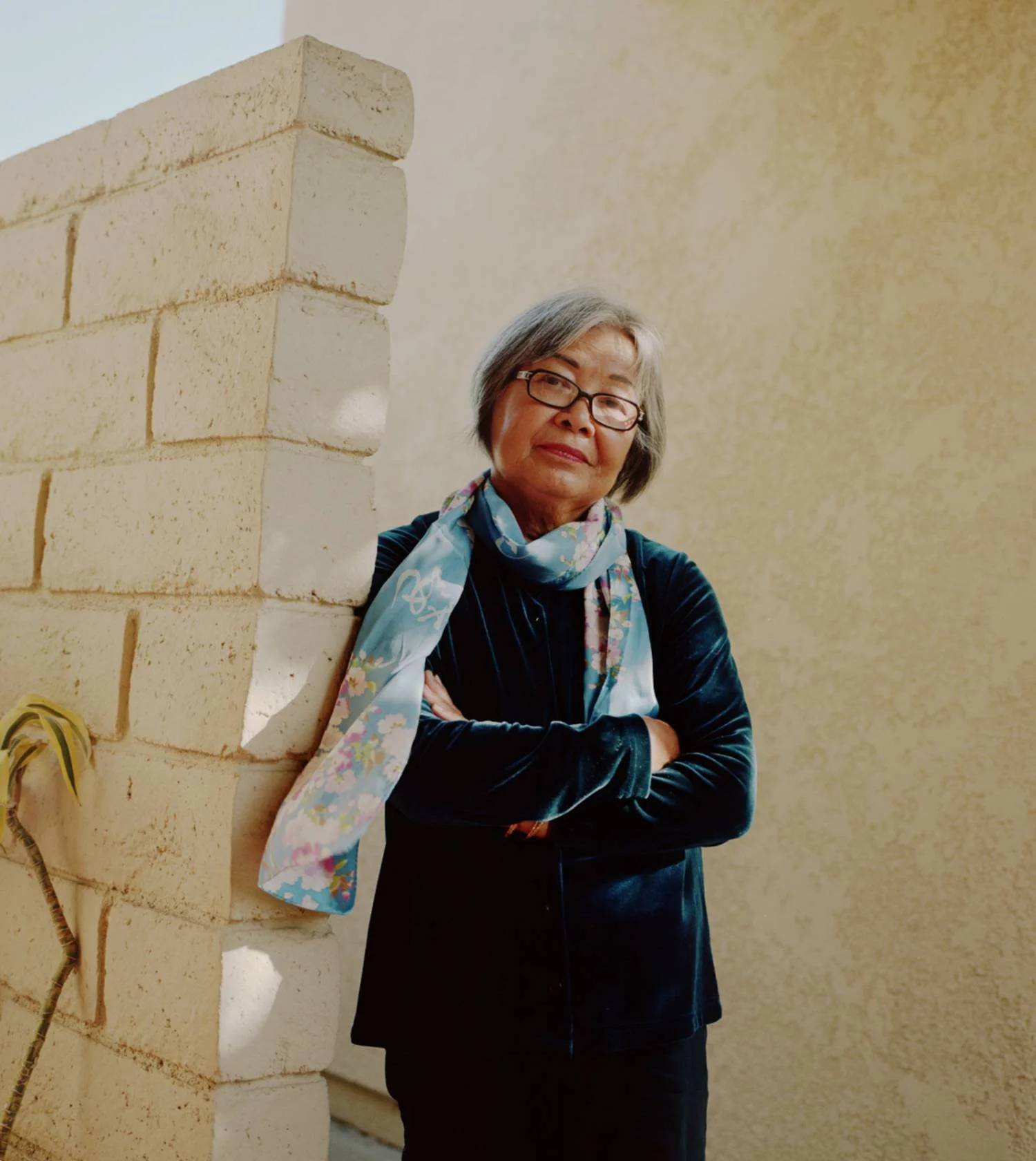 old woman leaning on a wall