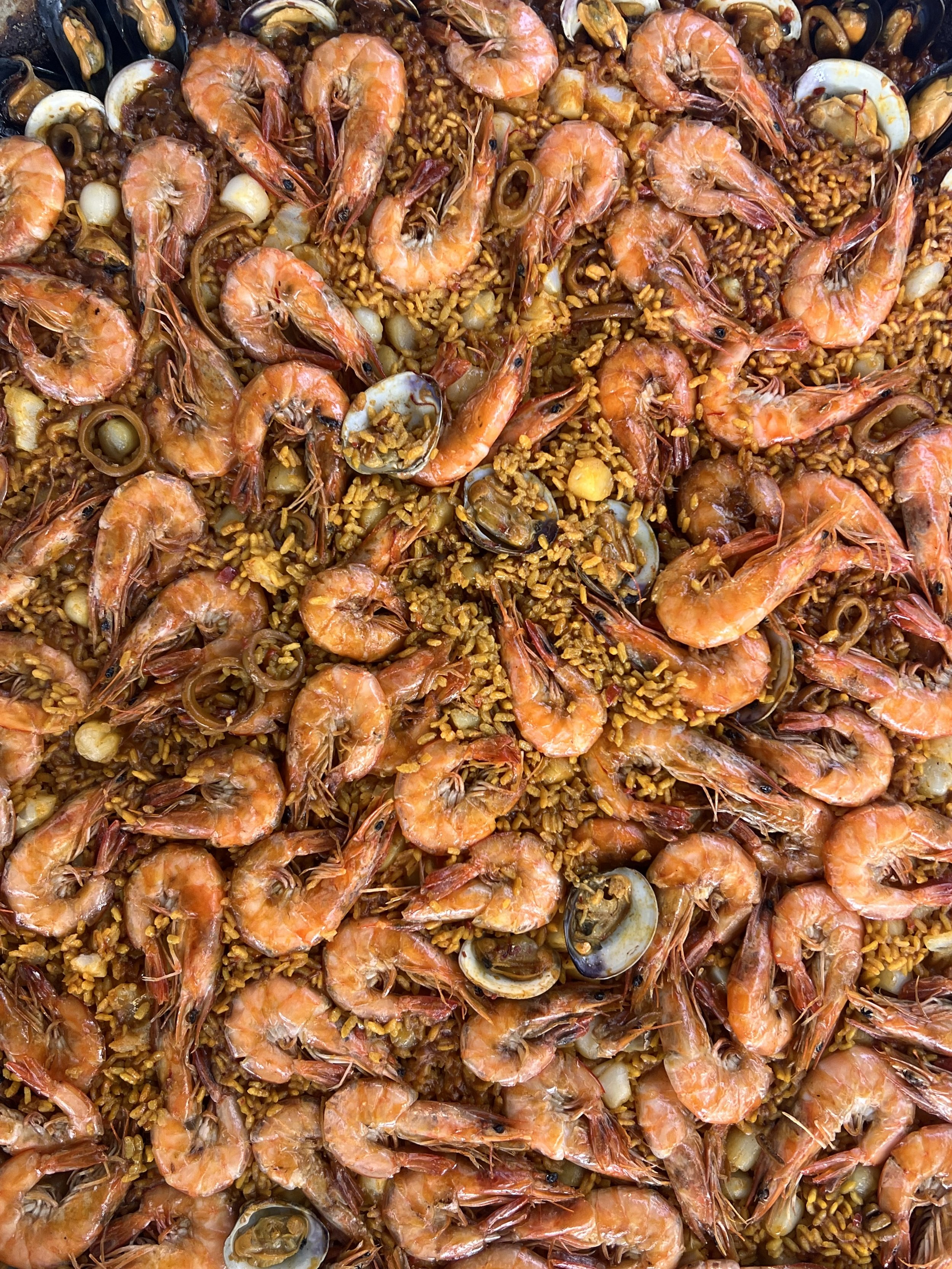 Close-up of a large pan of shrimp and rice paella with seafood made by Chef Diego Cerdan