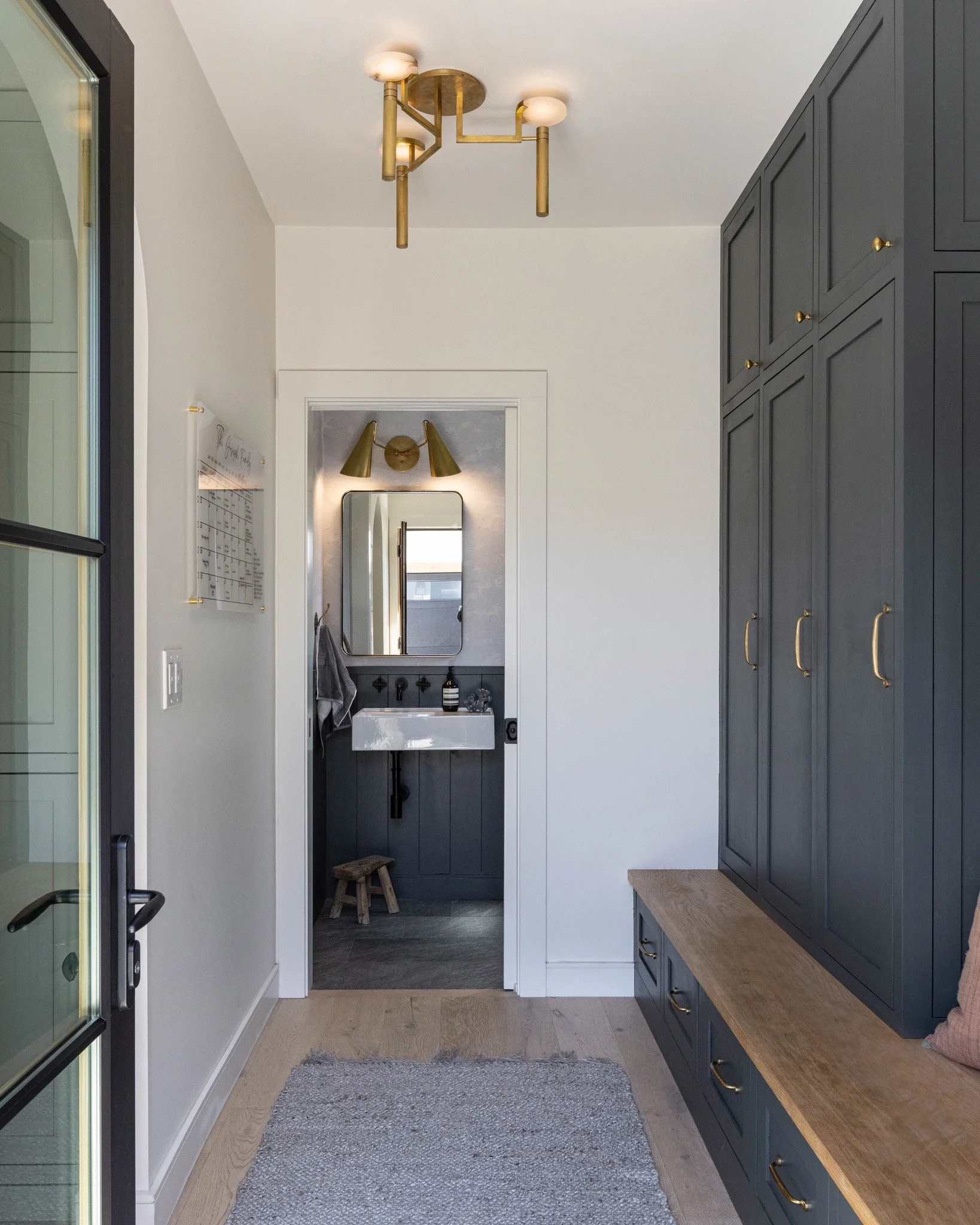 Mudroom view of the powder bathroom, floating vanity, mirror  and custom light fixtures