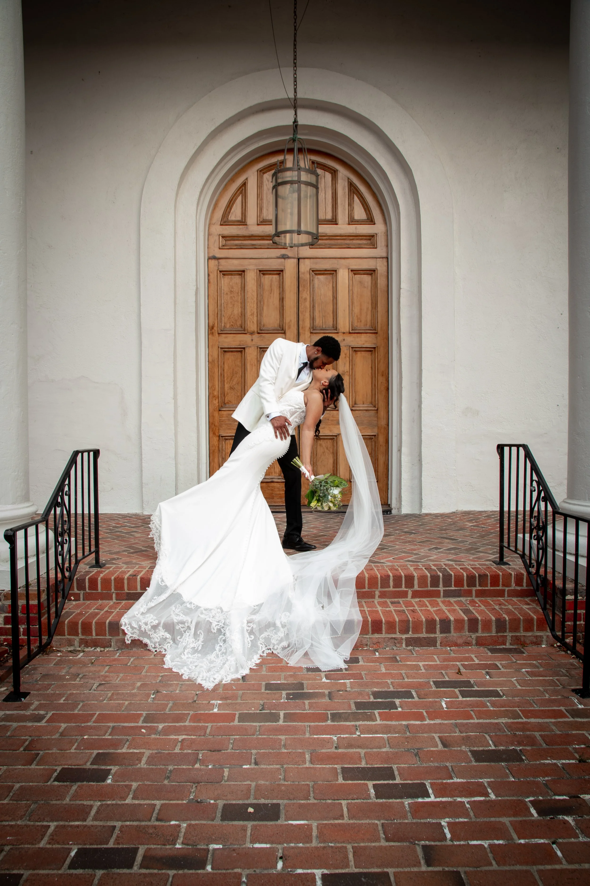 Bride and groom sharing a romantic veil portrait outside church steps in Little Washington, North Carolina.
