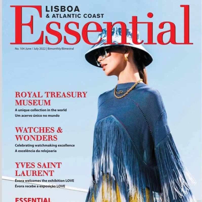 Cover of Lisbon & Atlantic Coast Essential Magazine, June/July 2022 issue, featuring a woman wearing sunglasses, a wide-brim hat, a blue sweater with fringe detail, and gold jewelry, with headlines about the Royal Treasury Museum, watches and wonders