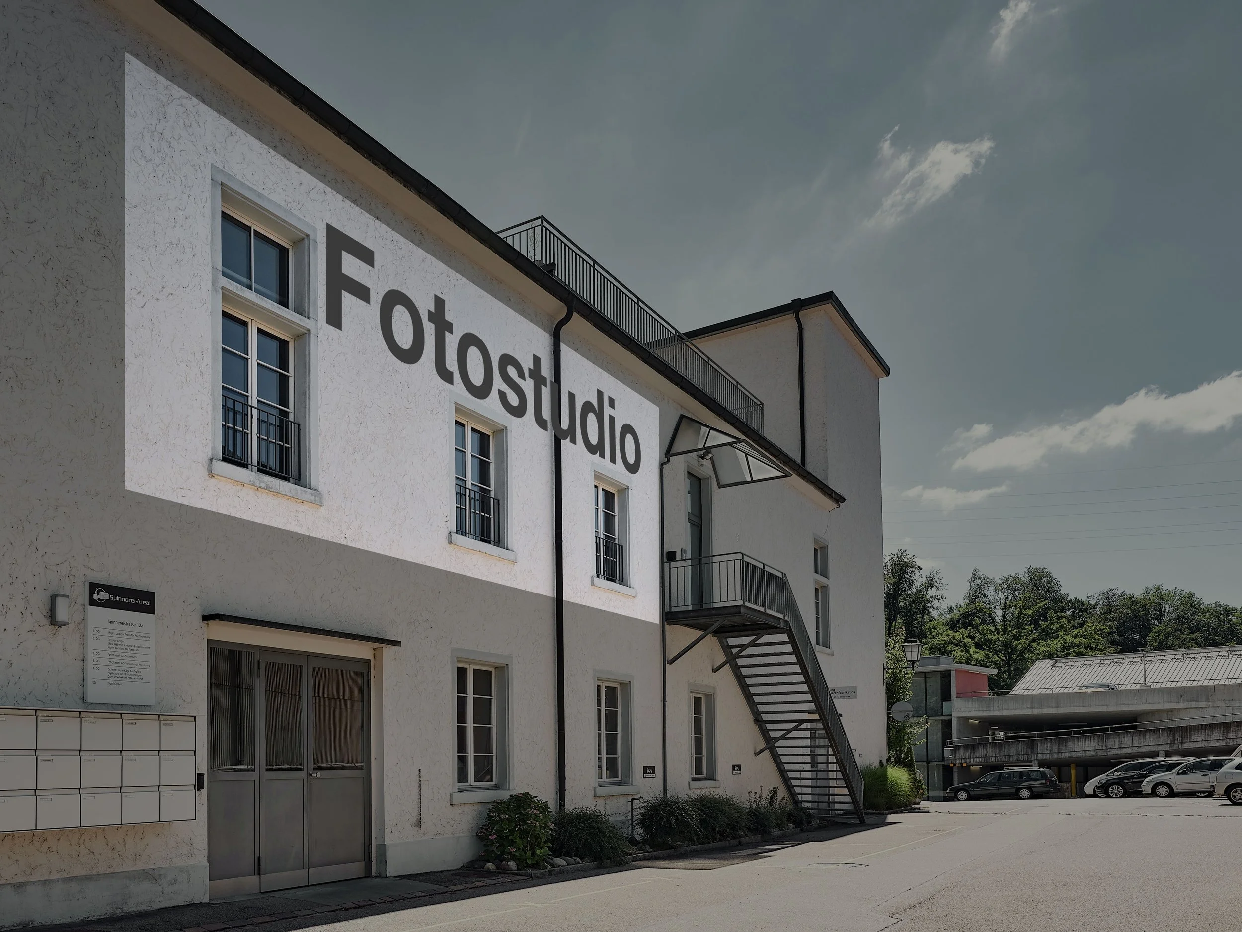 Aussenansicht des Fotostudios von Christoph Küenzi in Langnau am Albis mit Parkhaus im Hintergrund.