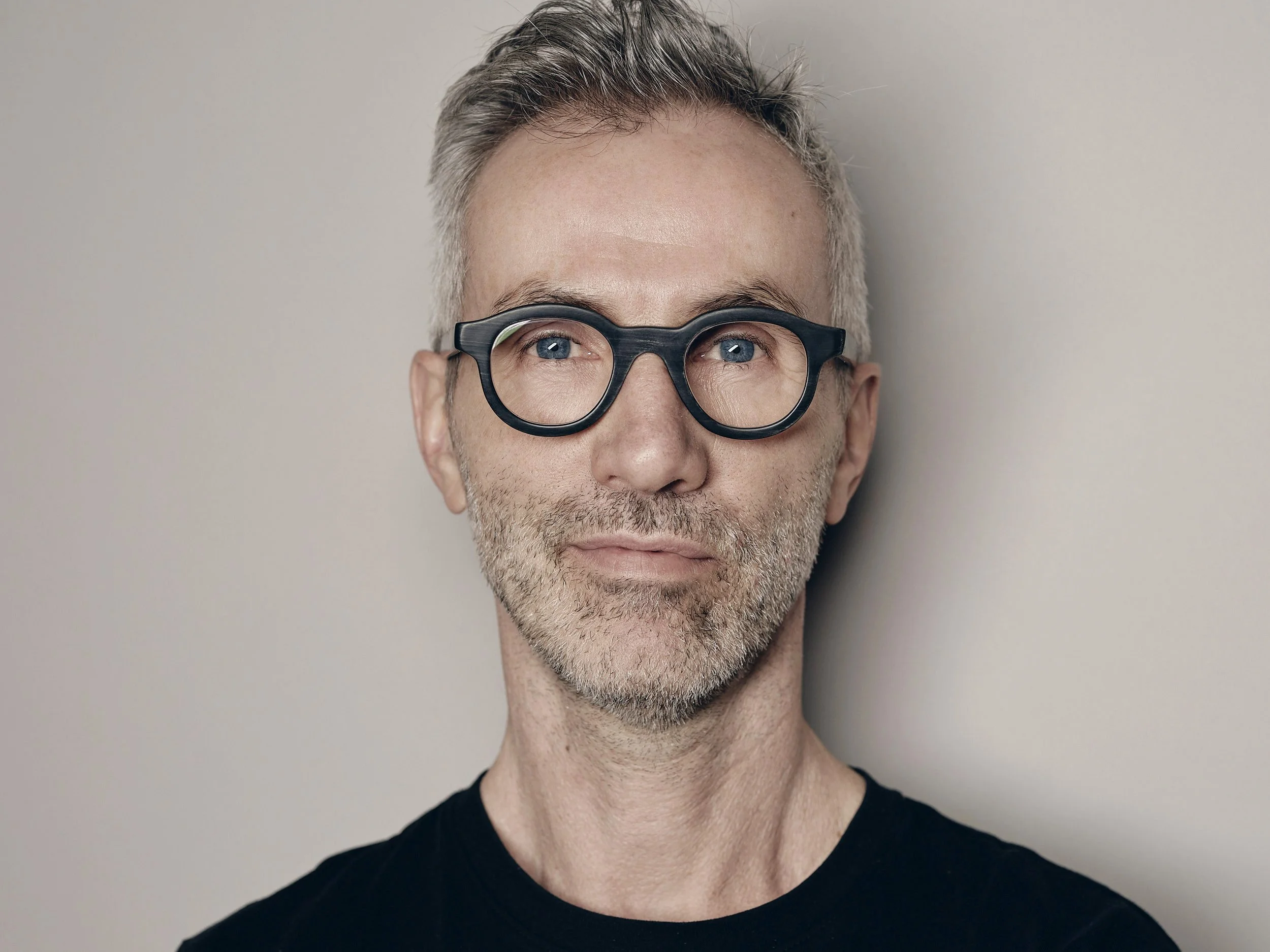 Portraitfoto von Christoph Küenzi, Fotograf in Zürich, vor hellem Hintergrund.