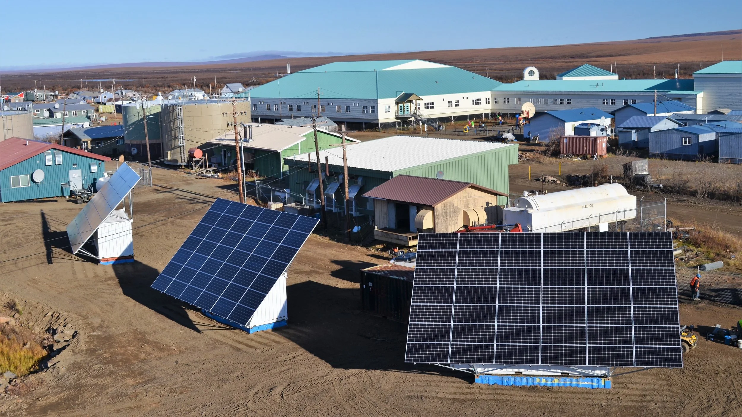 Photo of large solar panel arrays outside a compound of buildings in Alaska