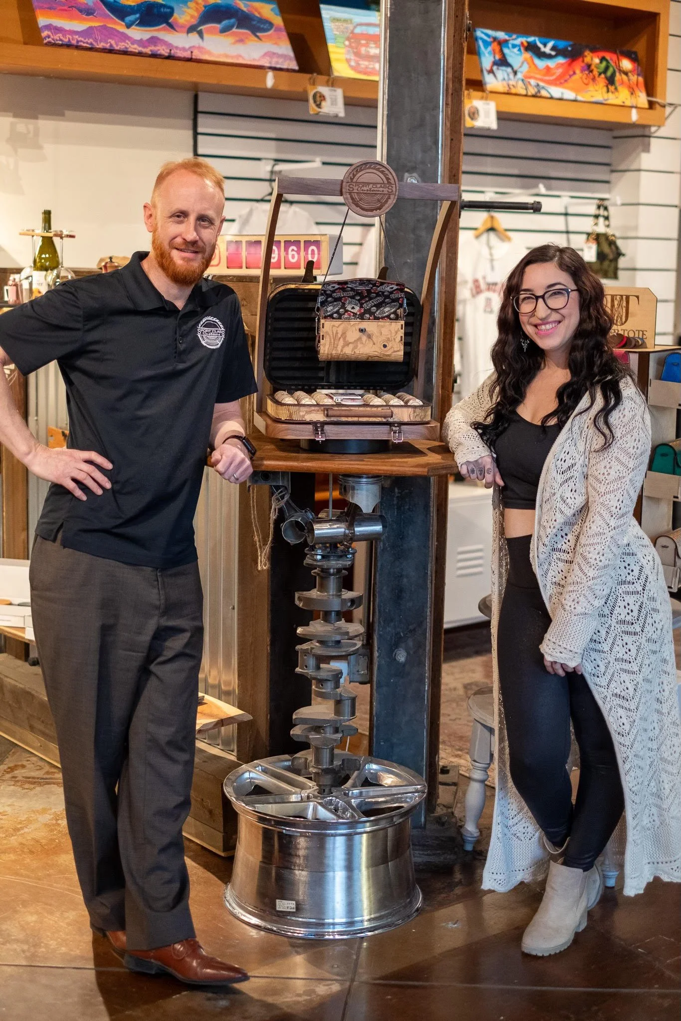 Jason Robinson and Chelsea Adler, co-inventors of the TimberTote, pose for a photo in front of a display in Robinson's woodshop