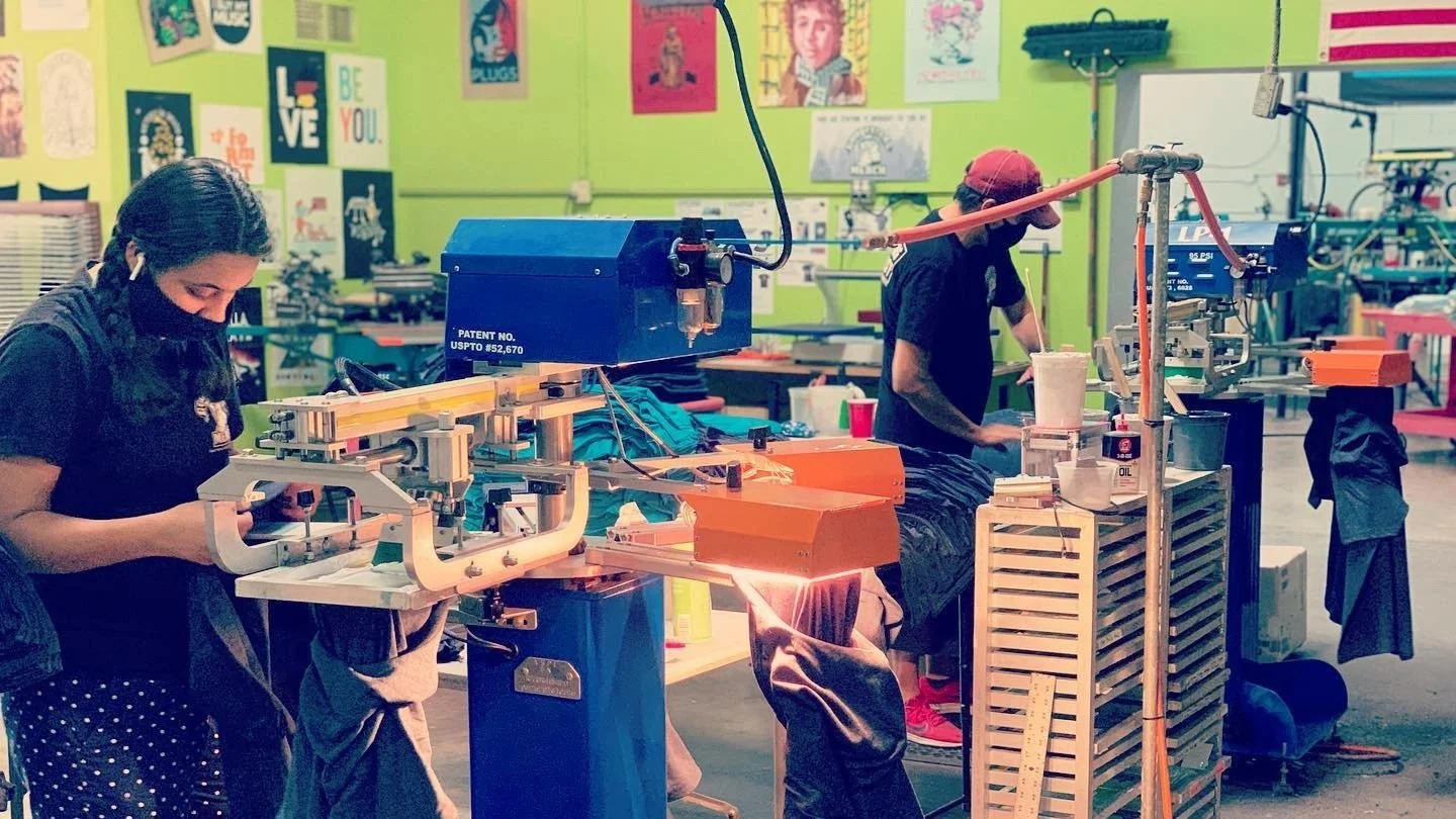 Employees work on screenprinting machines at Goodfellas Merch in Glendale Arizona