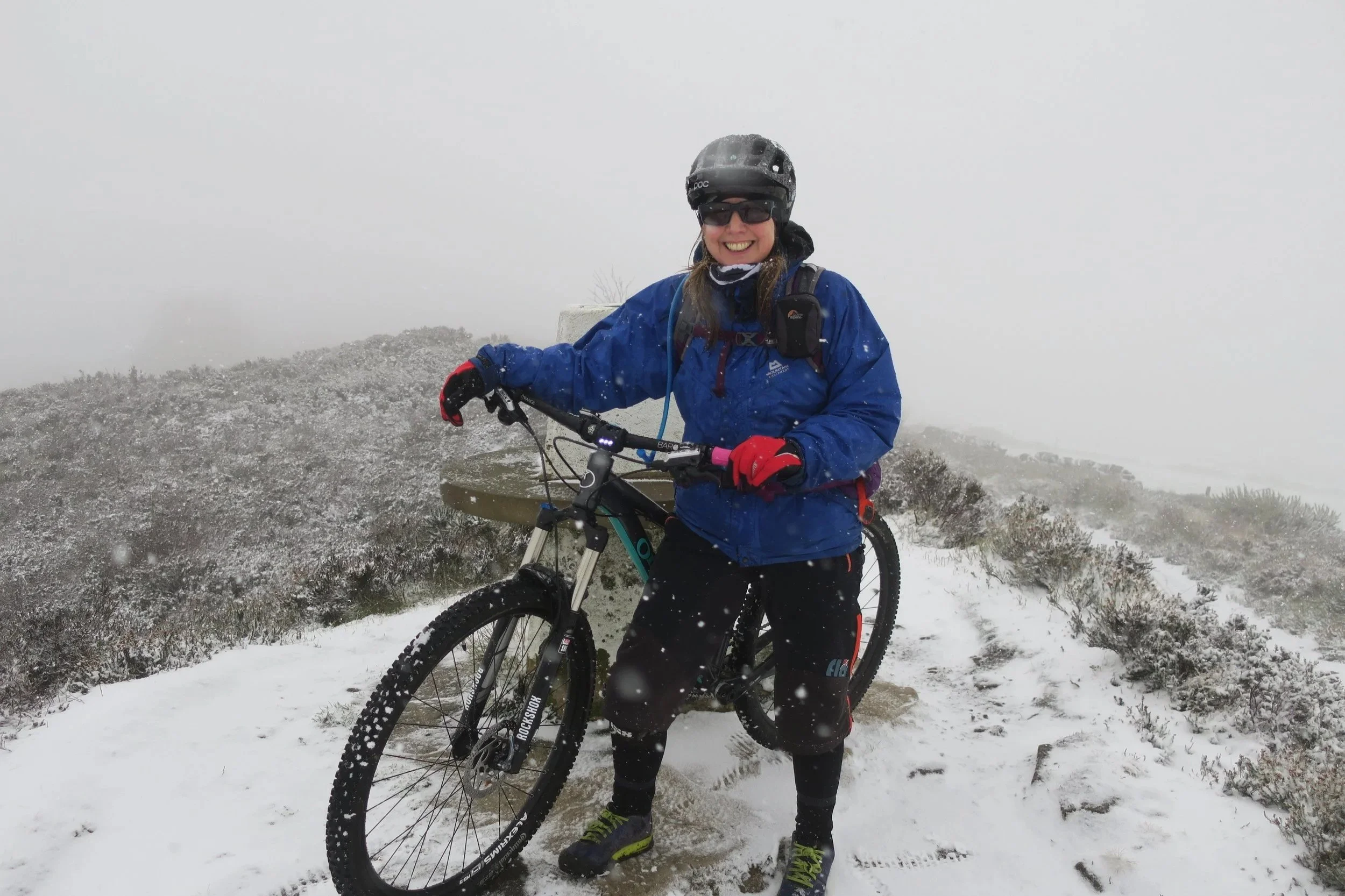 Cyclist in the snow wearing a blue Mountain Equipment jacket