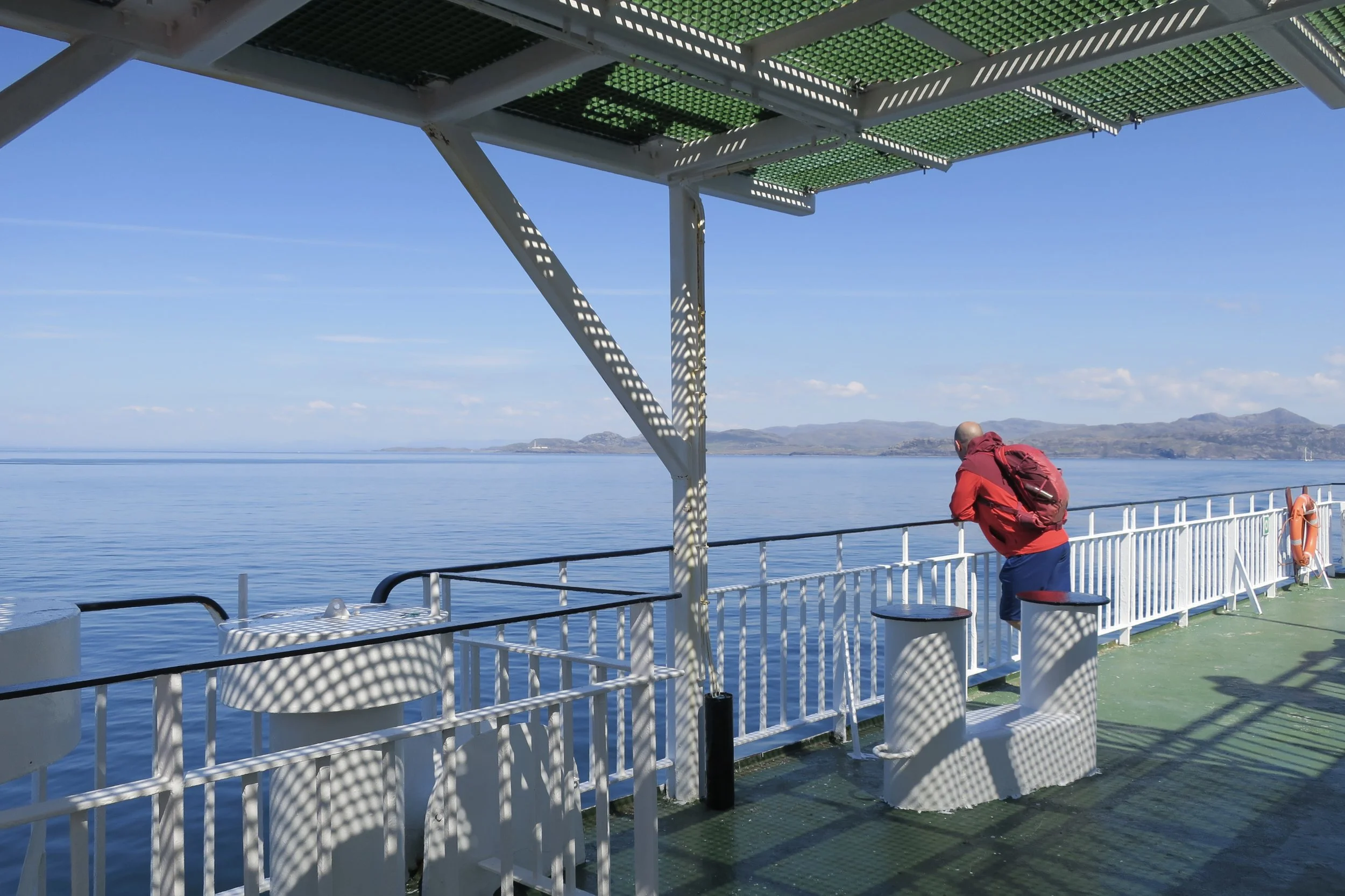 On the ferry from Oban to Barra, looking out over calm blue sea to distant land