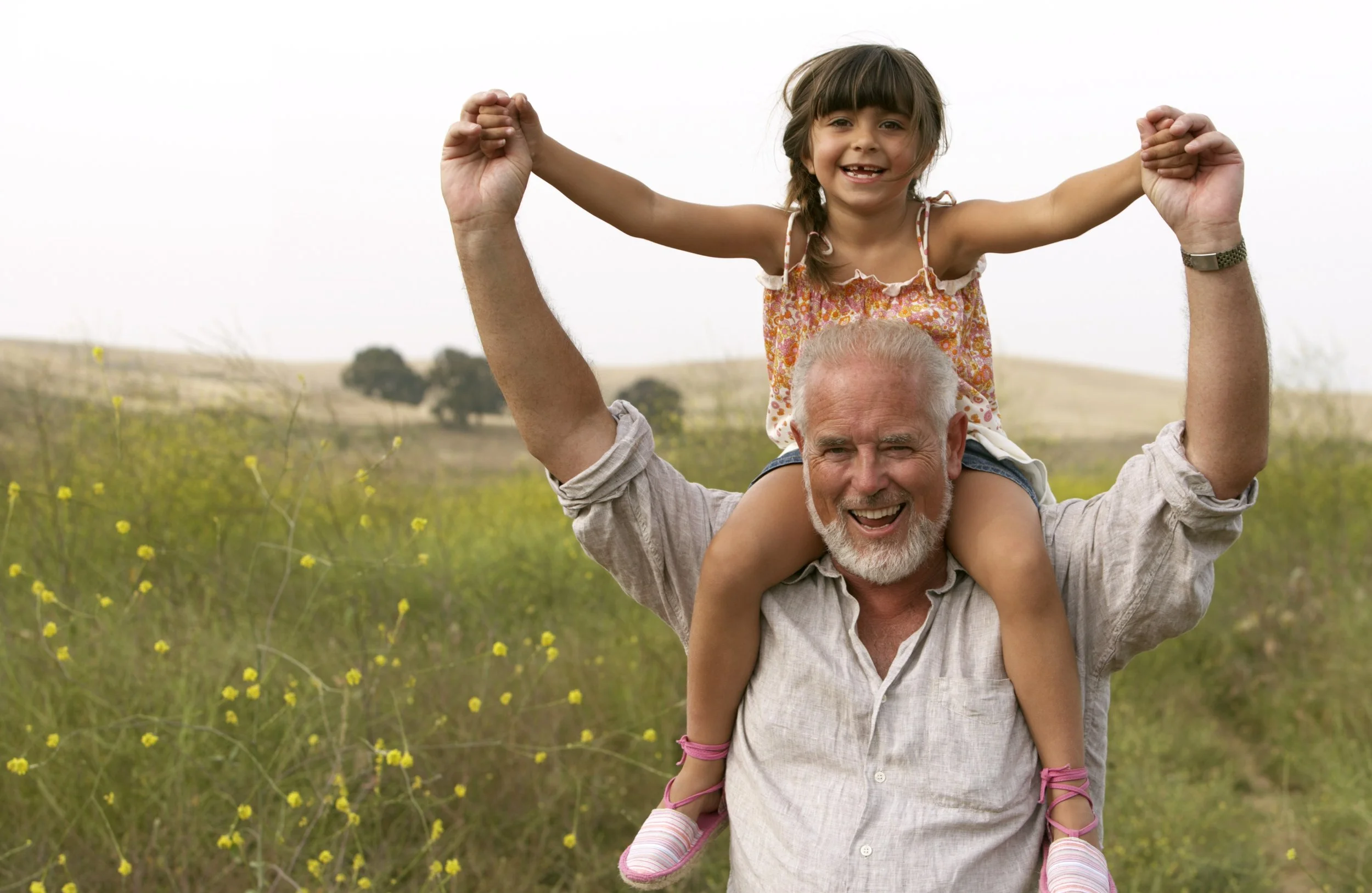 Guardian with kid on their shoulders in a pasture