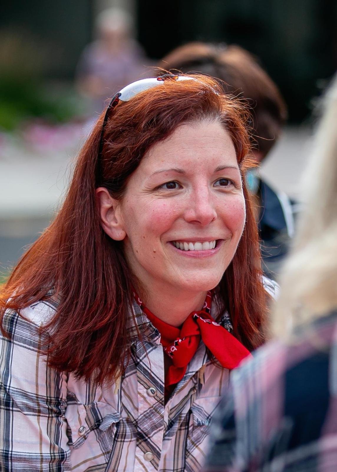 Susan E Rex giving a big smile. She is a beautiful woman with red hair