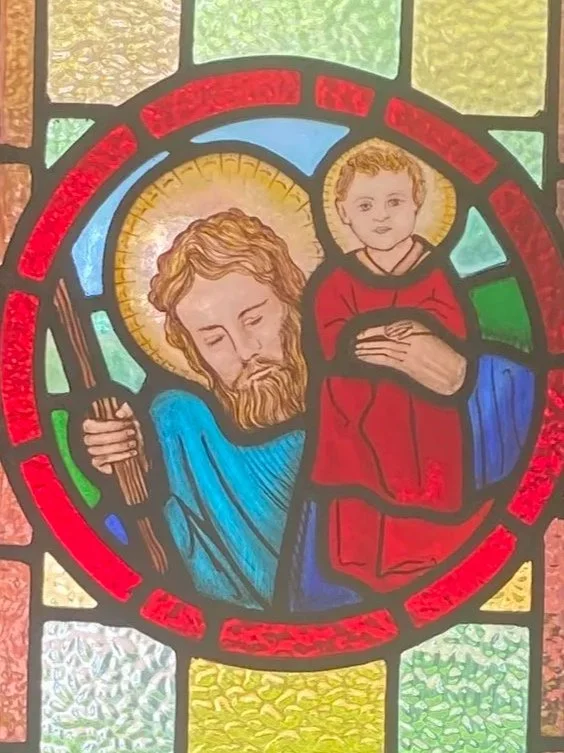 Stained glass window depicting St Christopher carrying the Christ child