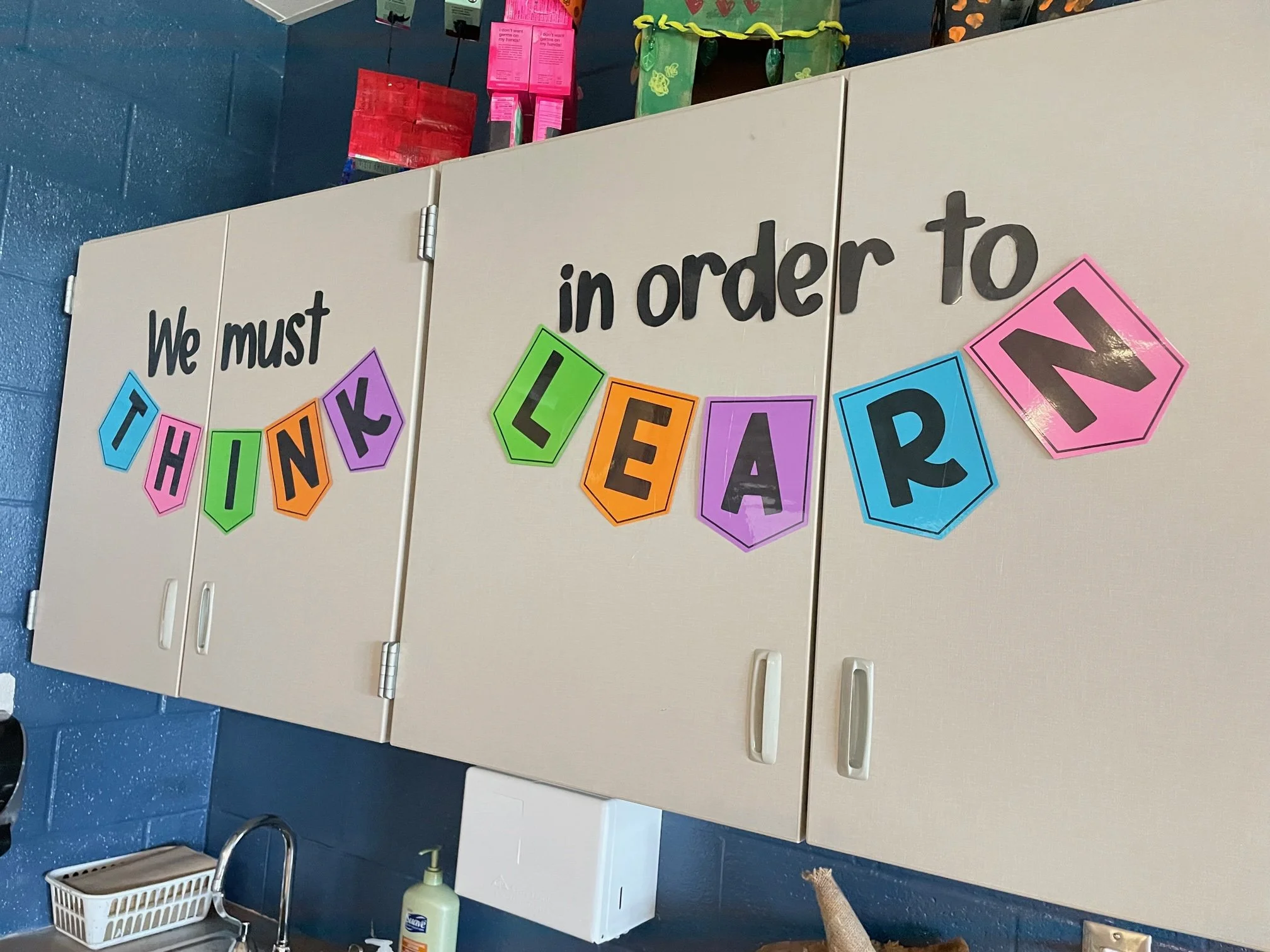 Classroom cabinets with banner that says, "We must think in order to learn."