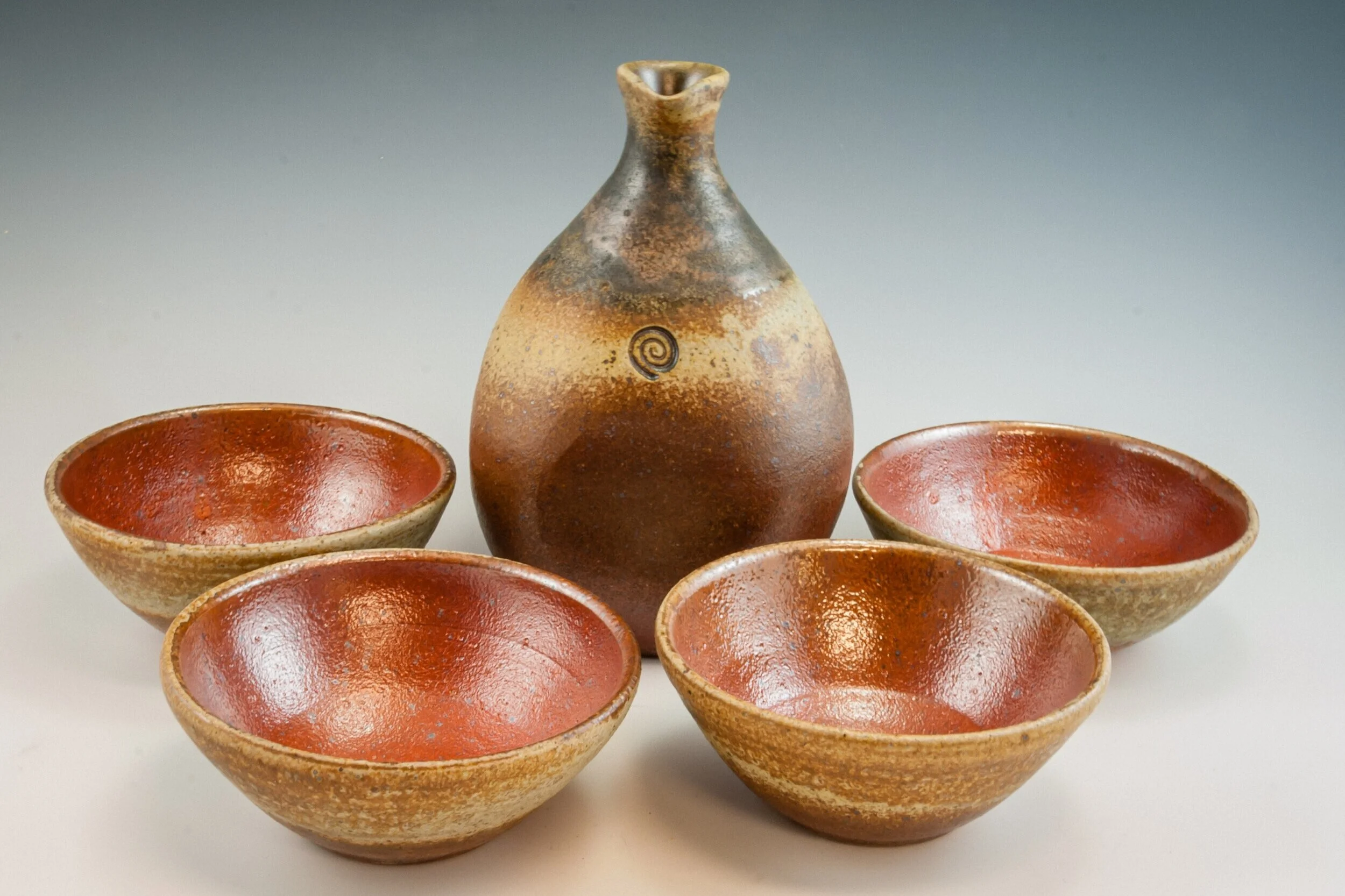A pottery set consisting of a pouring vessel and four drinking bowls