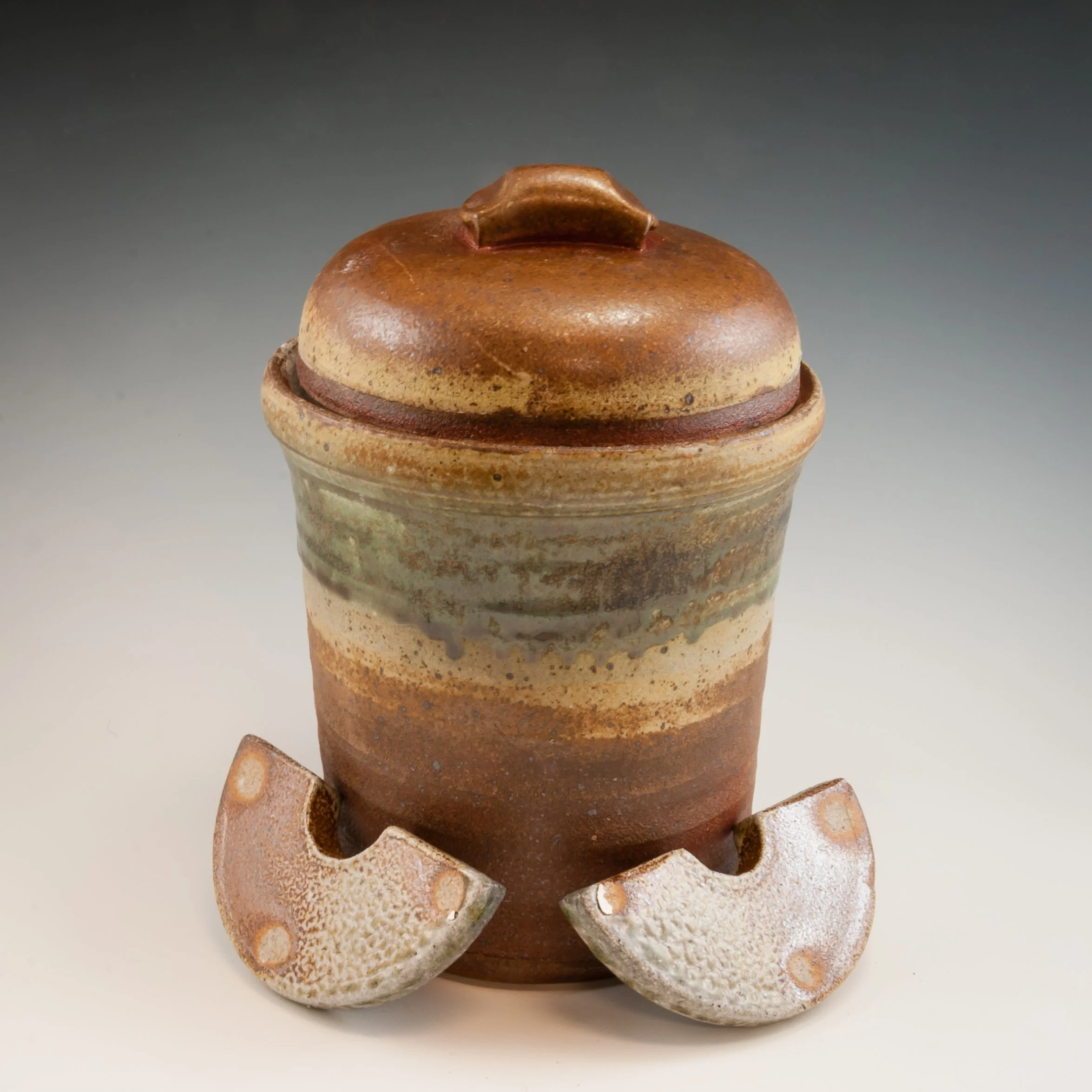 Various handmade ceramic vessels, including jars and cups, with earthy tones and textured surfaces.