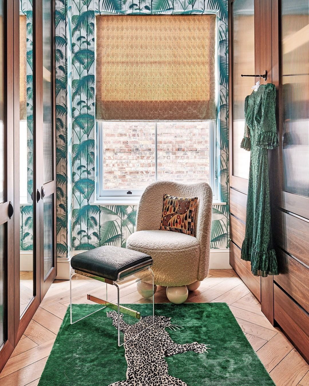 Make room for the rugs...🐆

In the dressing room, the vibrant greens of Cole &amp; Son's classic Palm Jungle wallpaper harmoniously complement playful leopard print accents. Verity's design choices, including walnut joinery and carefully selected vi