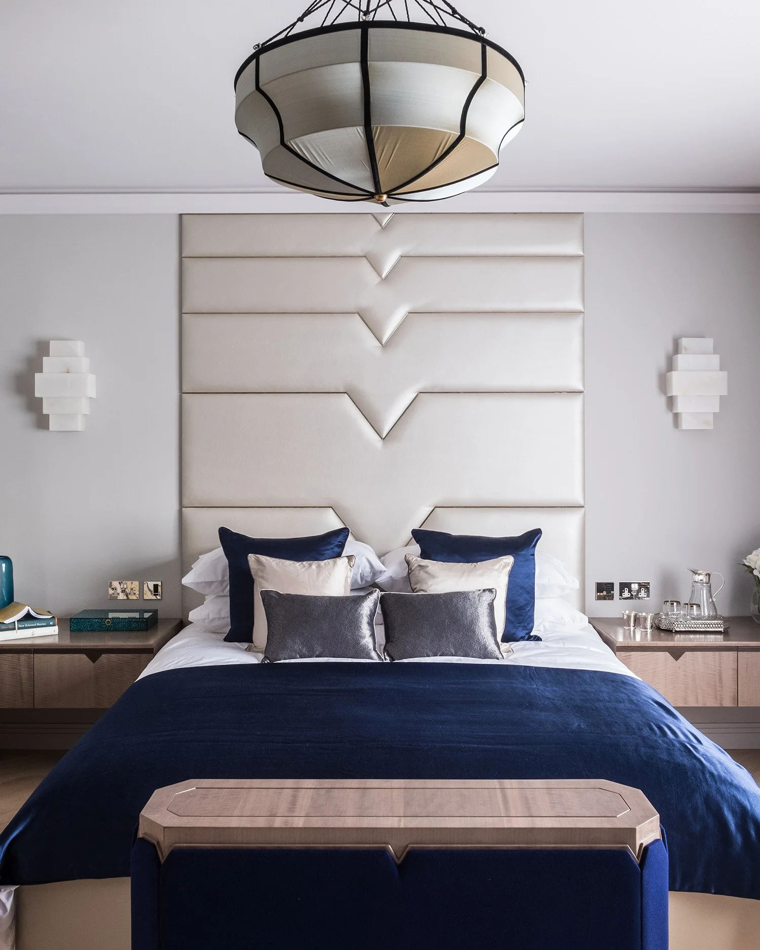 Three bedrooms, three very different designs. For the master bedroom we created a deco inspired headboard in a dappled faux leather to create a strong statement and placed a bespoke tv cabinet at the end of the bed in walnut timber with a royal blue 