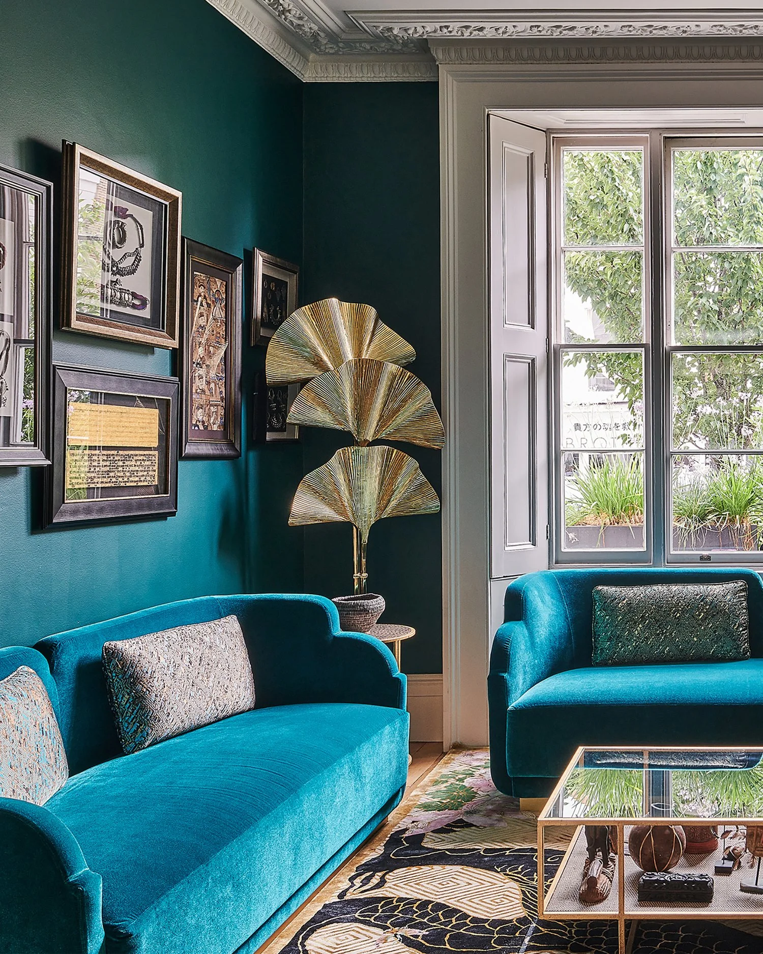 This living room is moody and imaginative, and the backgrounds of the family is immediately apparent in this colourful Notting Hill home. On entering the house the hall leads to this teal entertaining room with a club-style vibe. The colours in this 