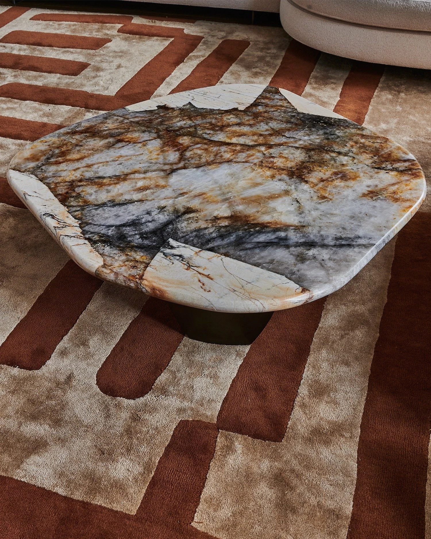 This organic marble coffee table is a bespoke WOOLF creation that is inspired by natural shapes and fine materials, accompanied by a hand woven rug, which we designed to add layers of pattern, warmth and originality. To create this one-of-a-kind marb