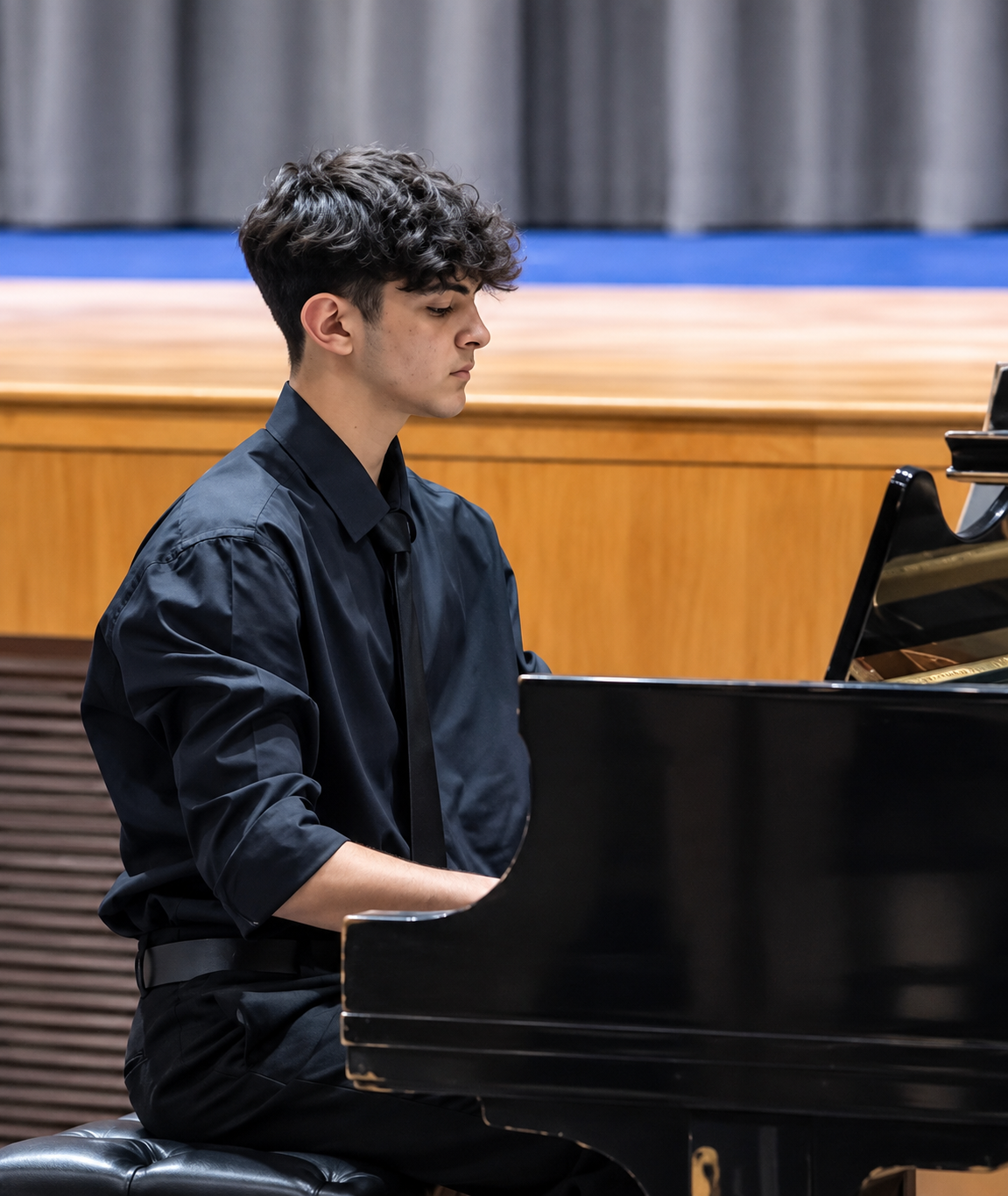 Young man playing the piano in a performance or practice setting.