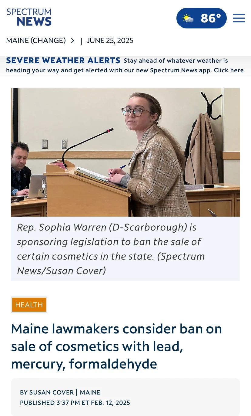 Screenshot of Spectrum News webpage with weather and news updates, showing a woman standing at a podium, wearing glasses and a checkered blazer, with a man seated behind her, and text about Maine lawmakers considering a ban on cosmetics containing le
