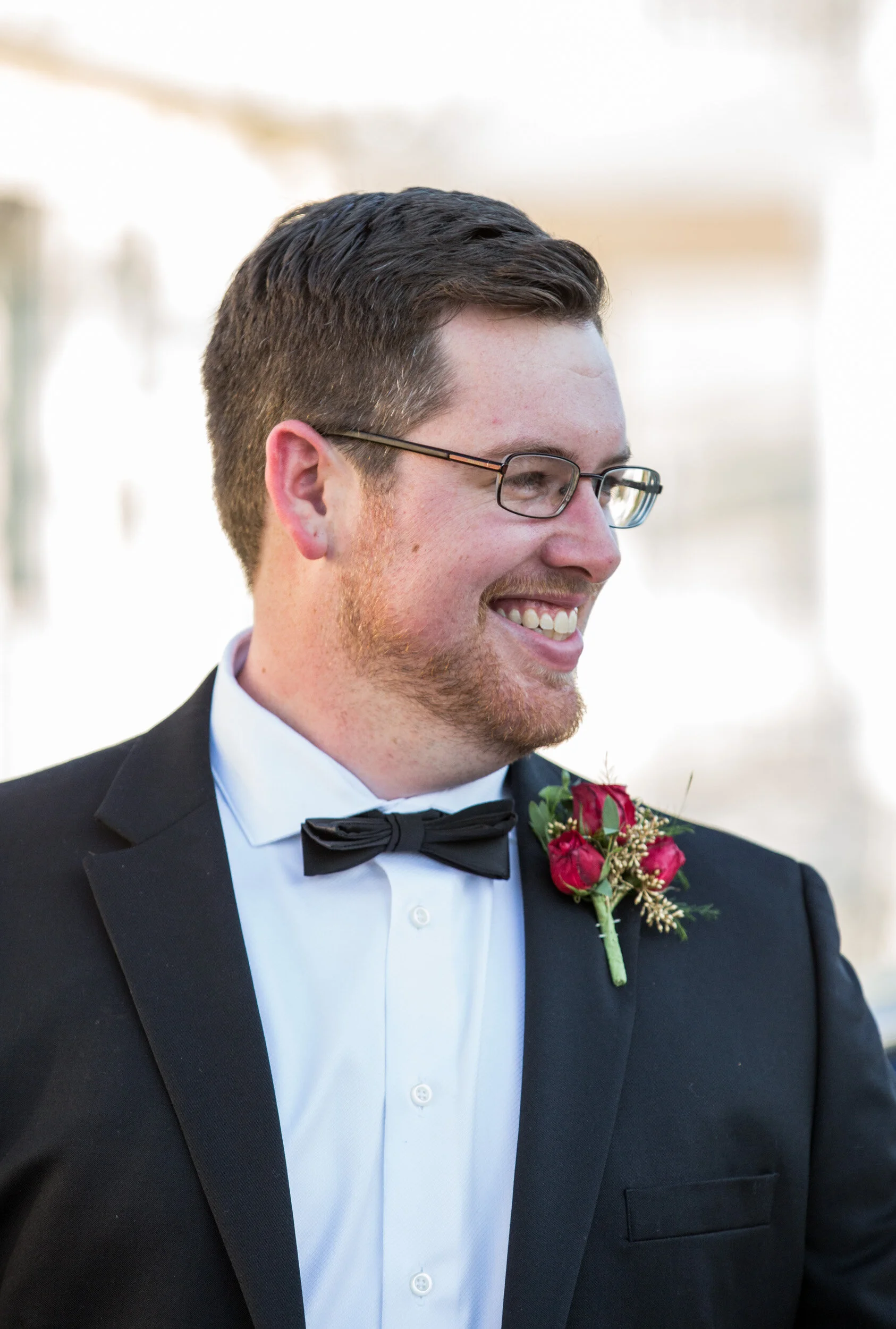 Smiling man in a suit with a rose boutonniere
