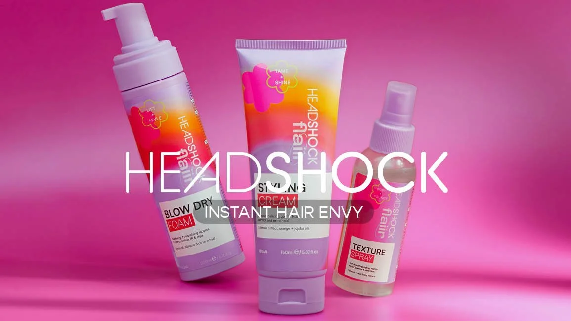 Three hair styling products on a pink background: foam spray, cream, and spray, with overlay text 'Headshock Instant Hair Envy'.