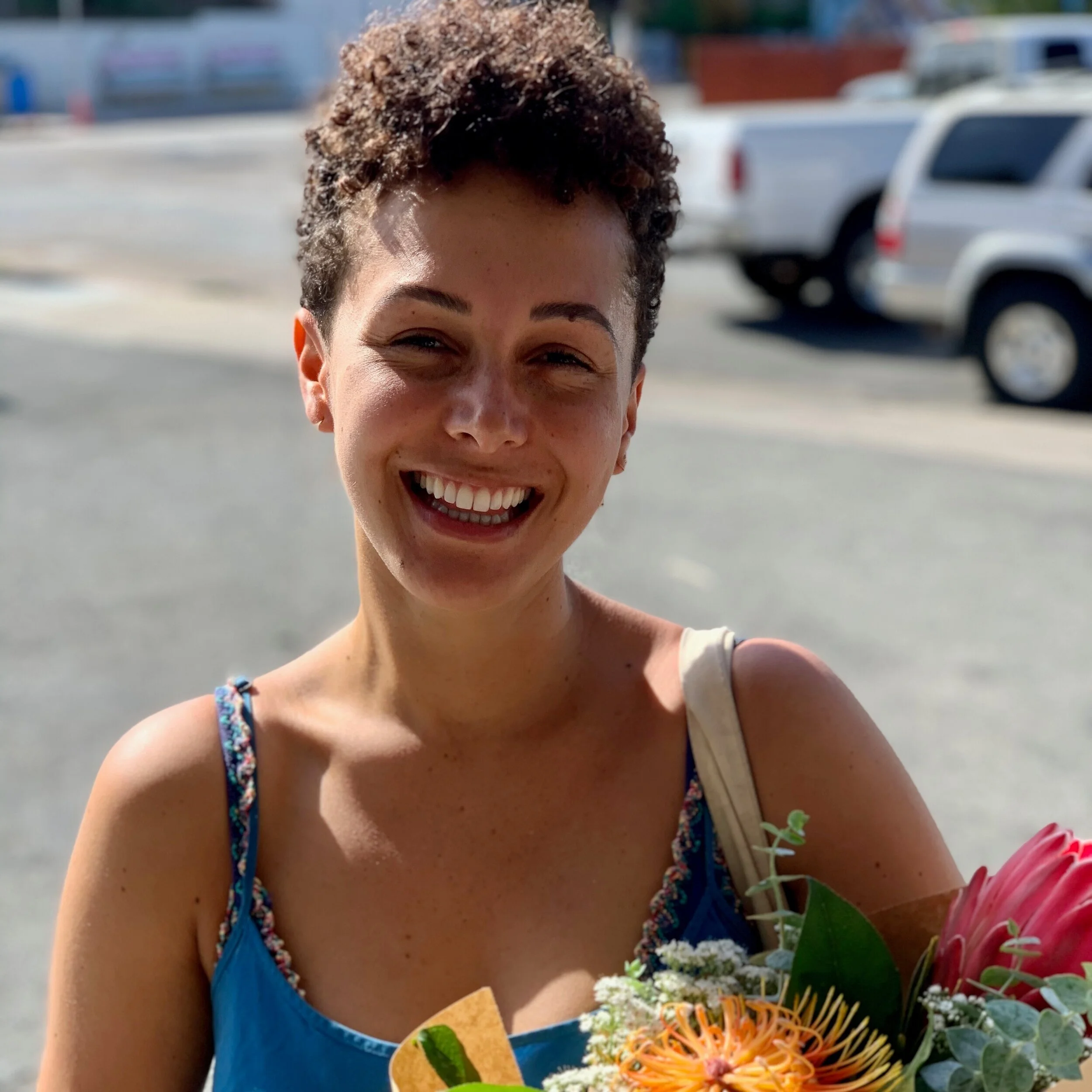 Lucy Anderle holding flowers outdoors and smiling