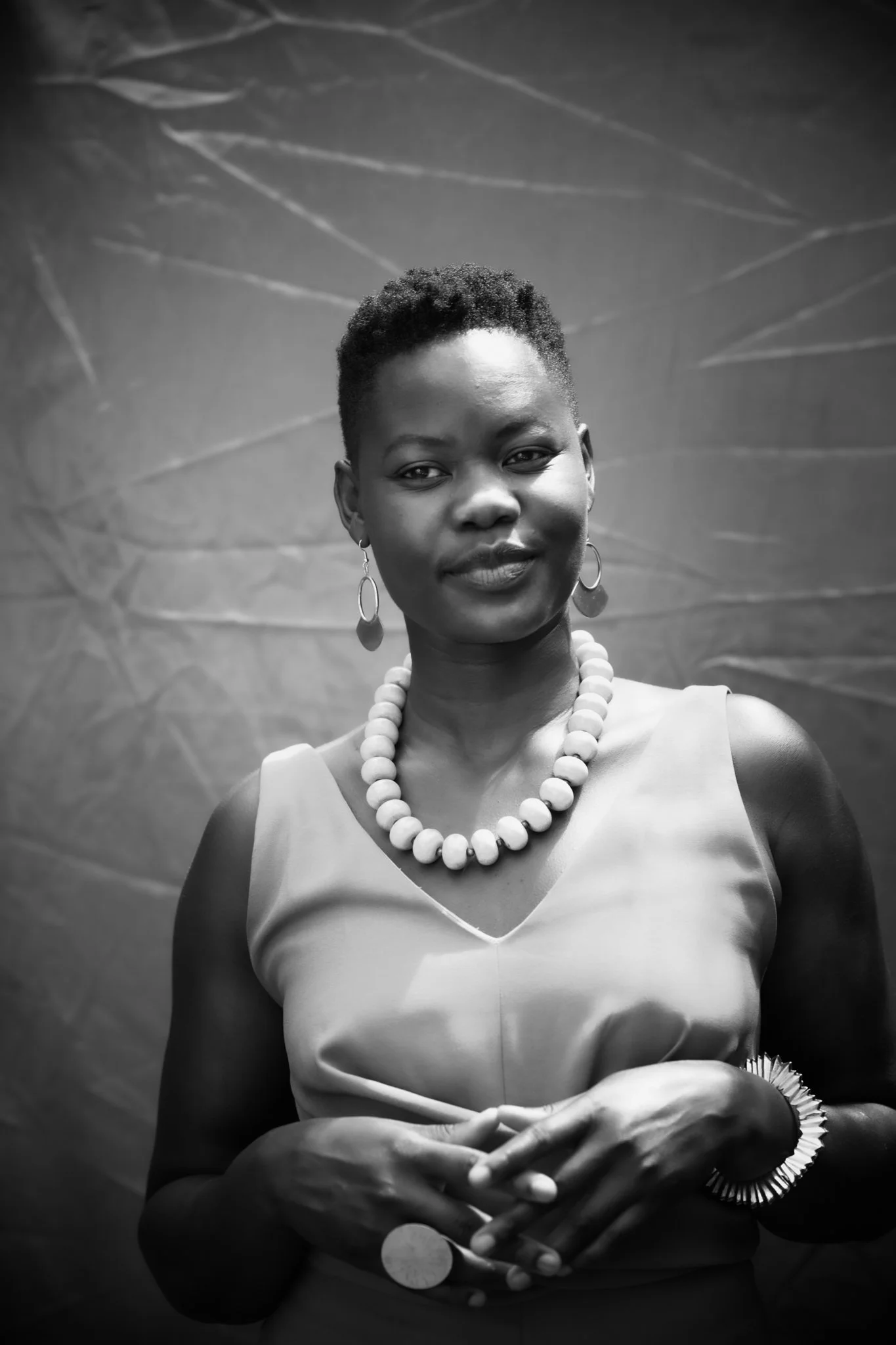 A black and white portrait of Alice Achayo smiling