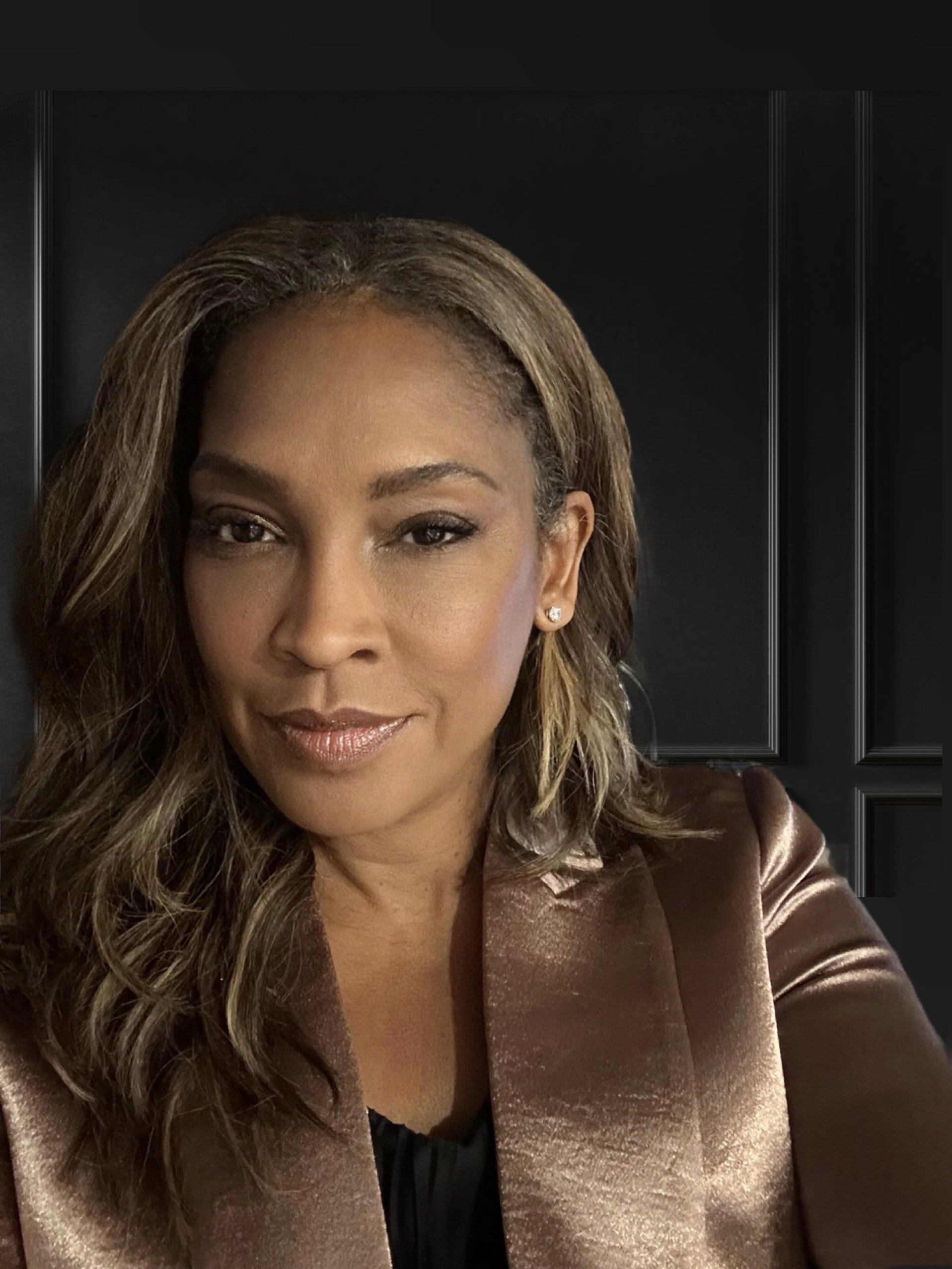 Jena Domingue smiling against a dark background