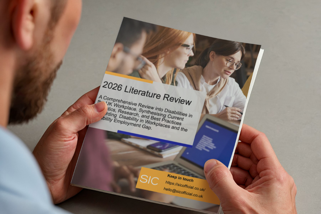 A white man with stubble holds a booklet. The front cover reads "2026 Literature Review"