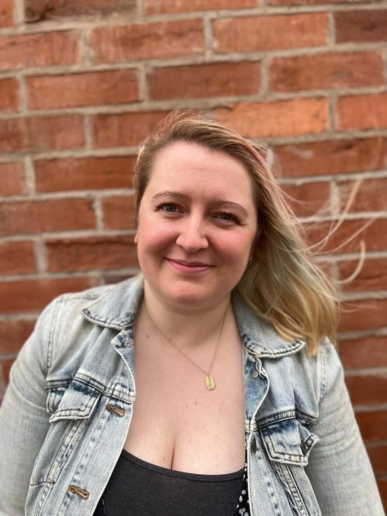 Photo of a white woman with blonde hair smiling at the camera