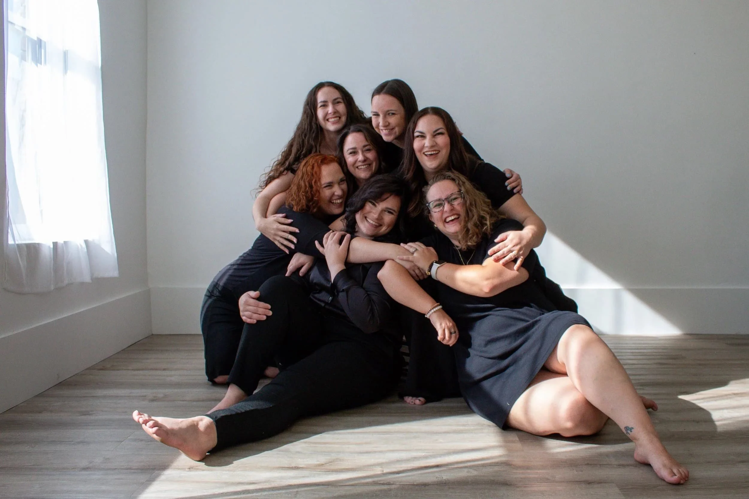 A group of doulas hug at the Collaborative Doula Conference during a networking event in London, Ontario.