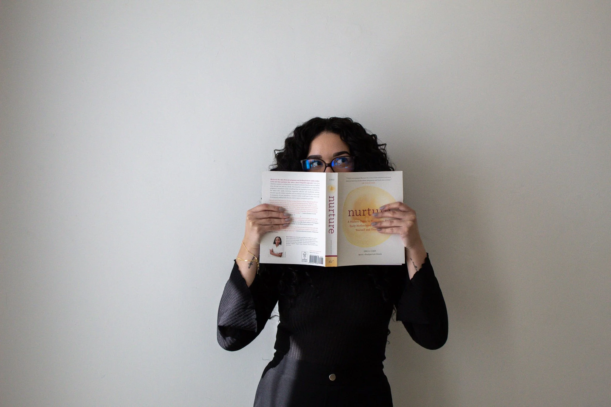 A birth doula holds a book to her face that was recommended at the Collaborative Doula Conference in Ontario, Canada.