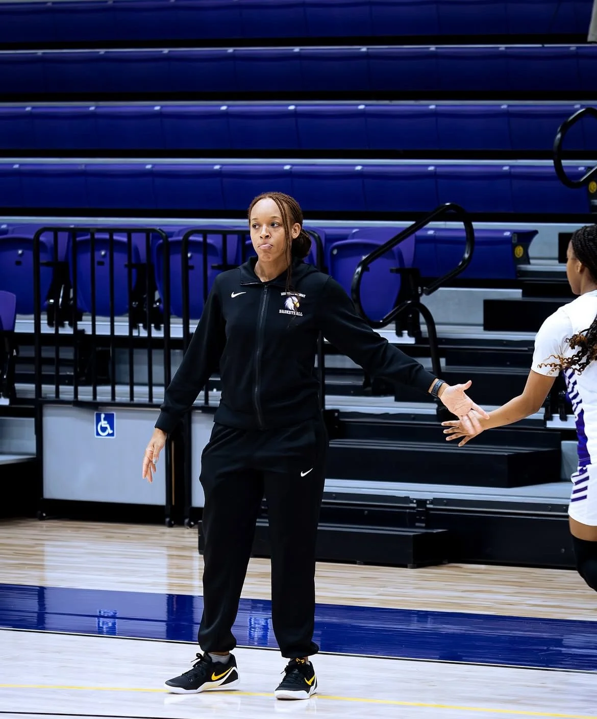 Taneka hand dap as student who's walking off the court, supporting athlete in a Montverde Basketball Game