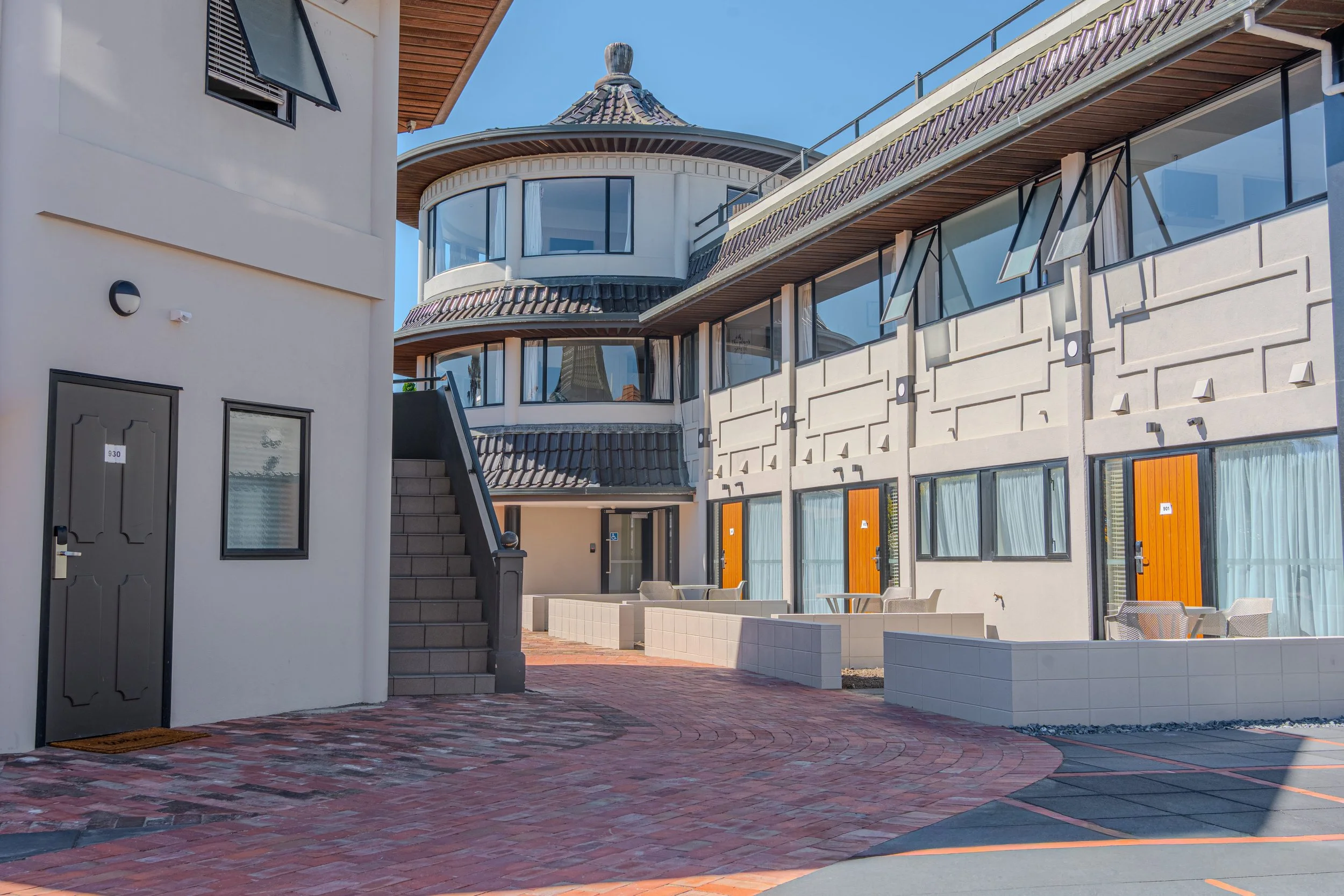 Outdoor courtyard area featuring guest room access, landscaped walkways, and communal spaces.