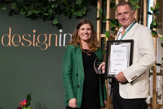 Award presentation for luxury hotel of the year at hospitality industry event with recipients holding trophy and framed certificate on stage