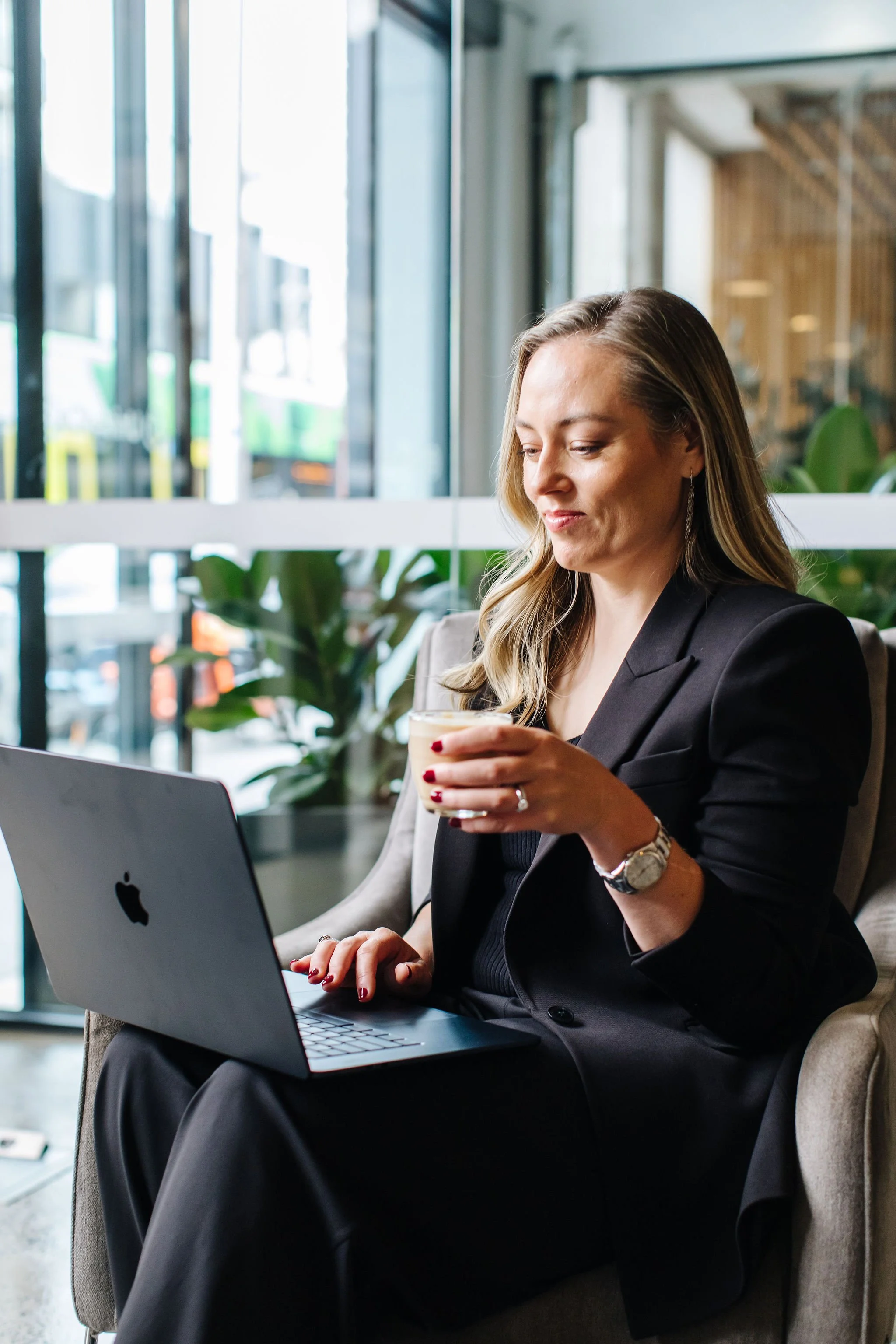 Rebecca Kartel holding a laptop and coffee as founder and director of The Kartel Solution. Bookkeeping Services Xero Training