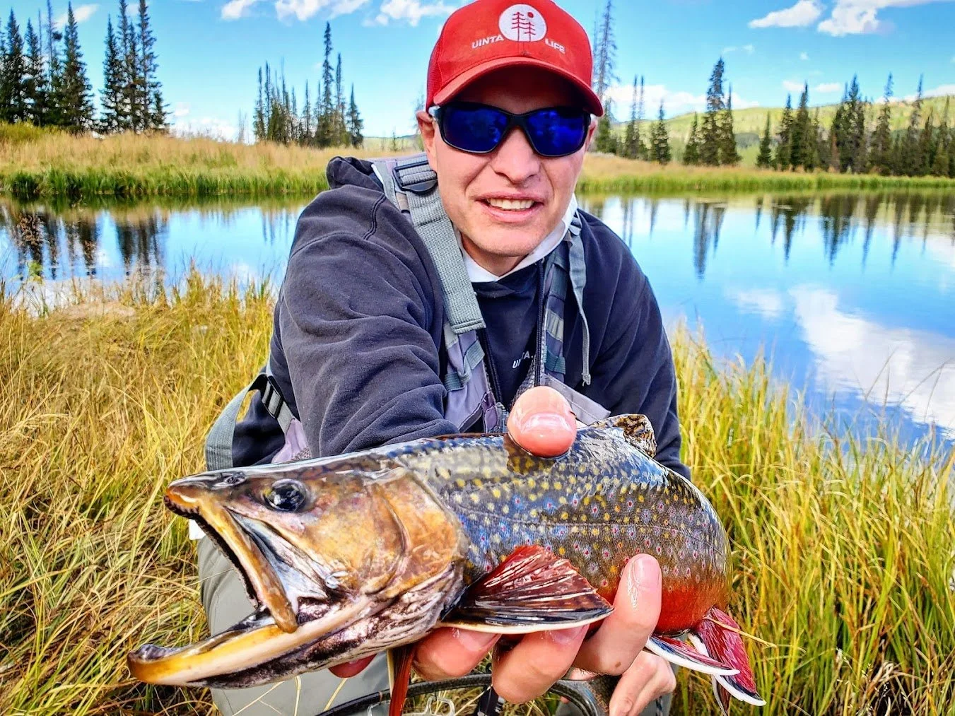 Rich Goates holding a brook trout that he caught in the Uinta Mountains