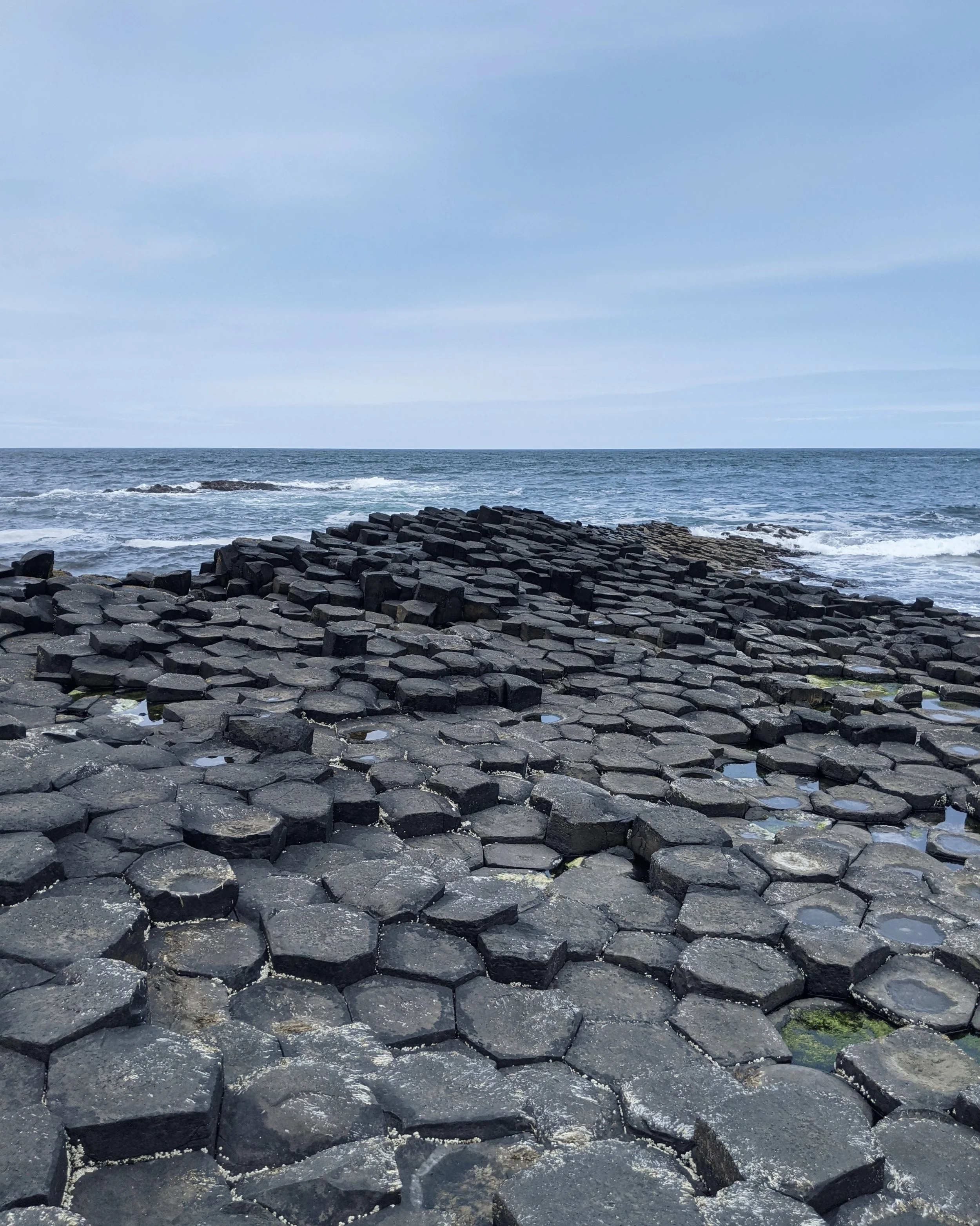A section of the giants causeway where the mostly hexagonal basalt rocks reach out to the choppy sea beyond
