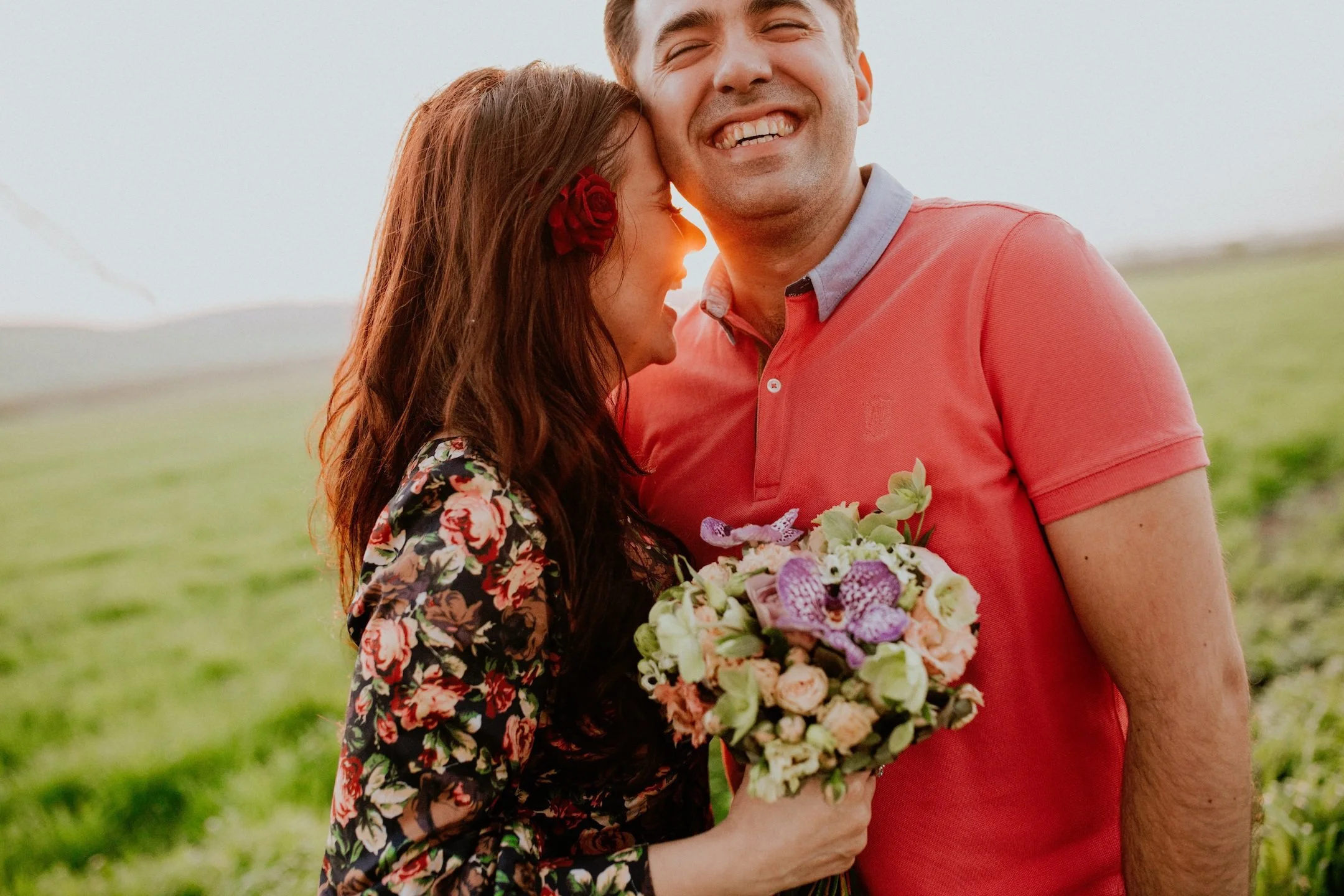 A smiling couple holding flowers