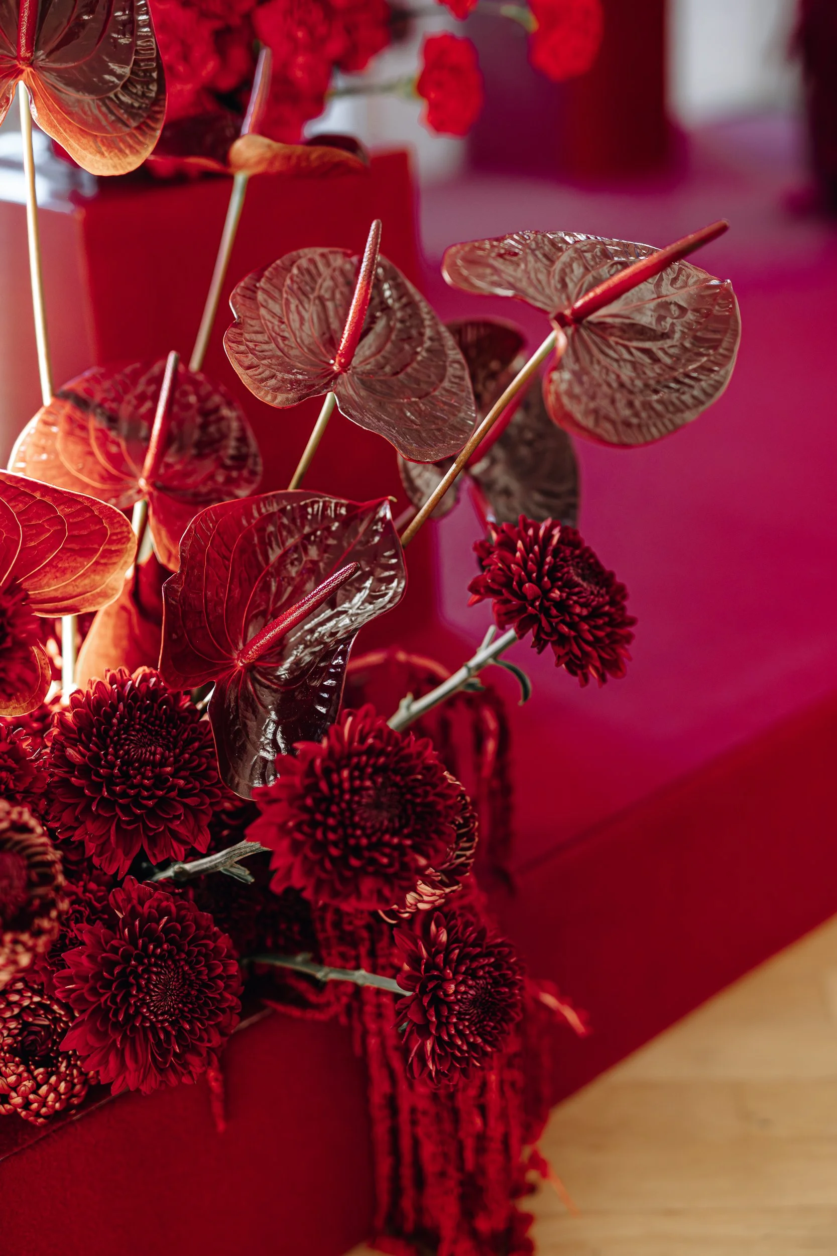 Close-up of red flower bouquet with dark leaves and red wrapping.