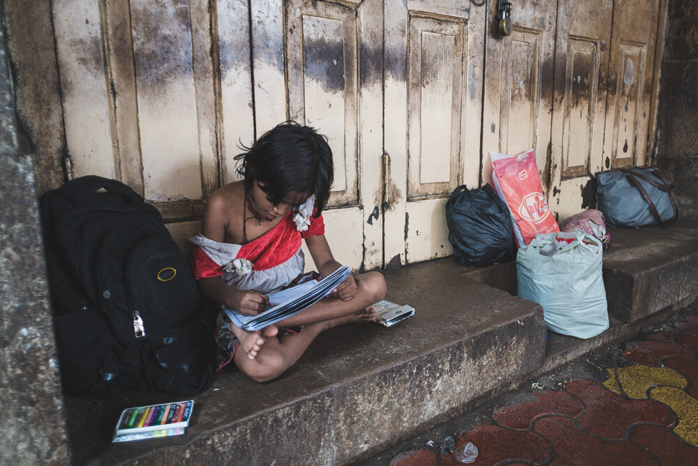bambina che studia per strada