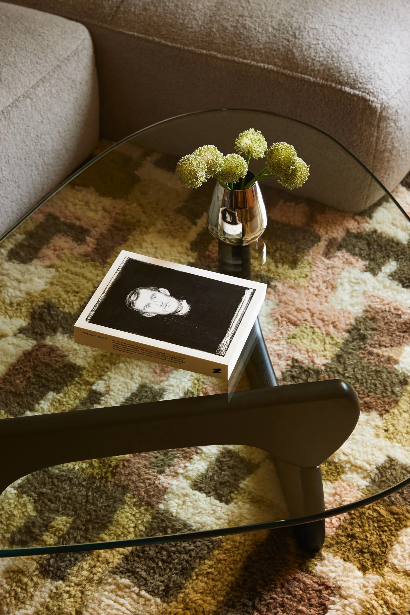 Interiørdetalj fra fotostyling, der tekstiler, blomster og objekter bidrar til en helhetlig presentasjon før foto og visning.