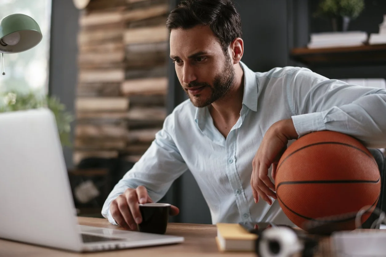 sweet 16 direct ltx blog photo of a man with a basketball looking at a computer